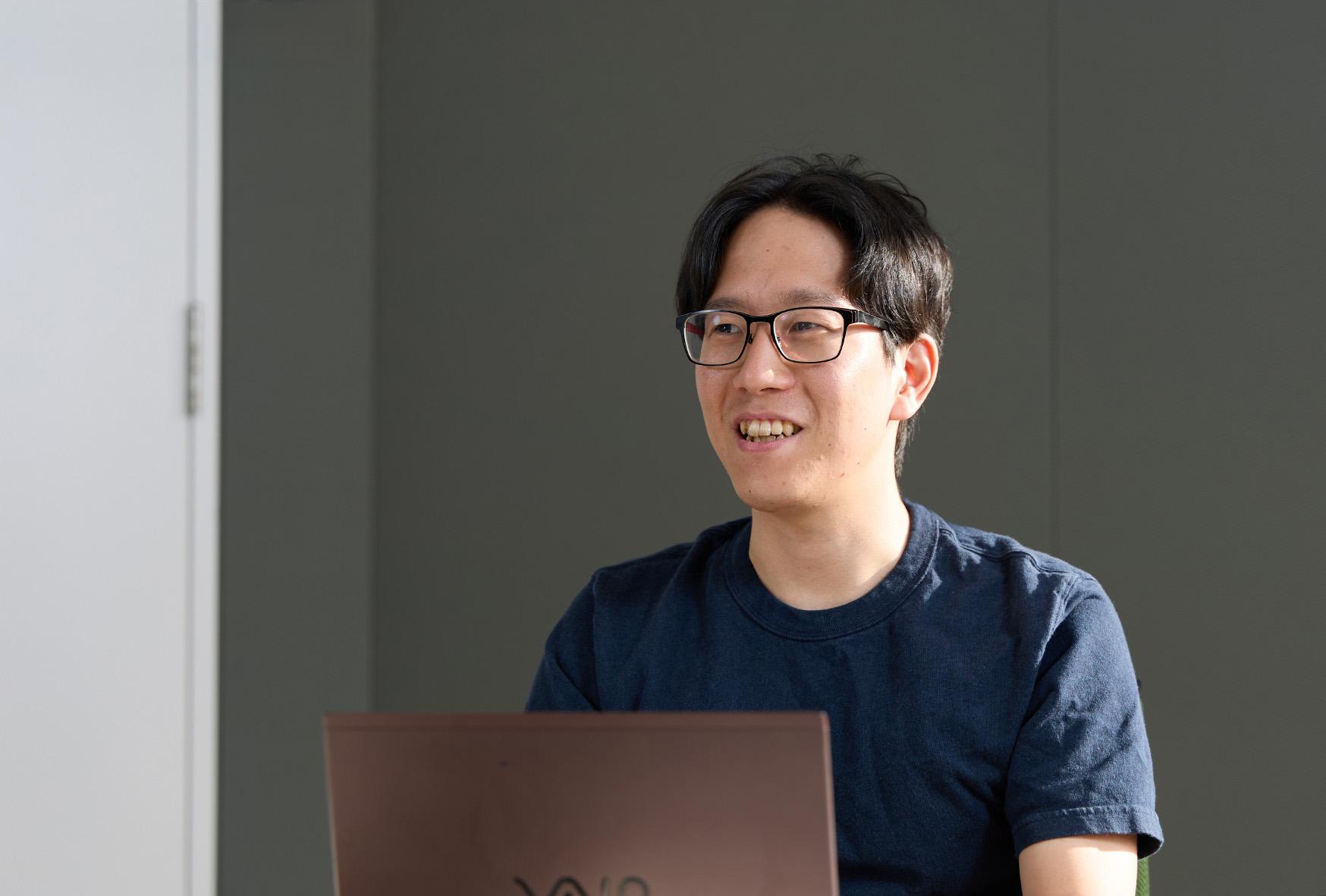 経営企画部 データ・インテリジェンスグループ長 田中 佑典氏がPCを前にしてインタビューに答える様子