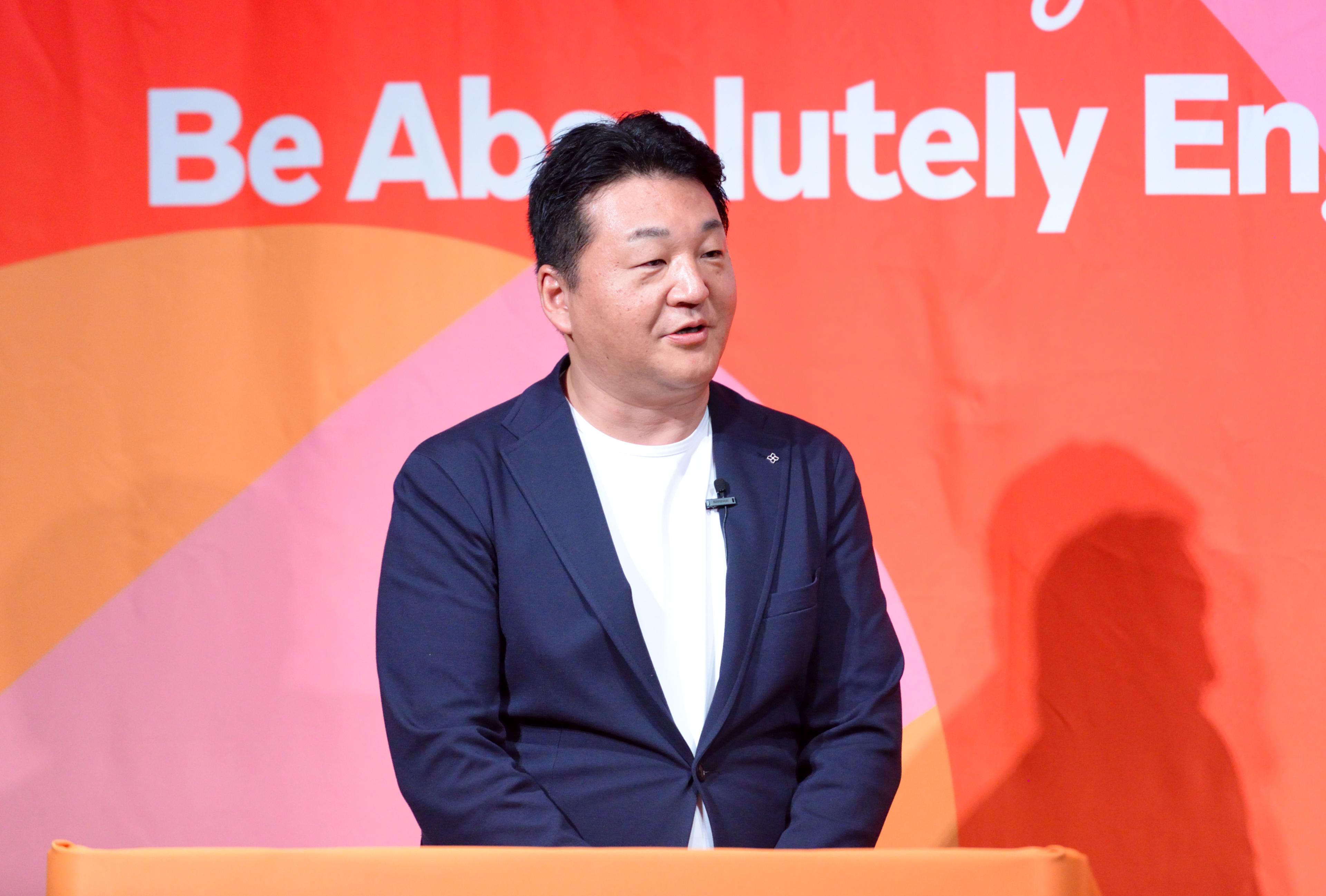 a man in a suit is standing at a podium giving a speech .