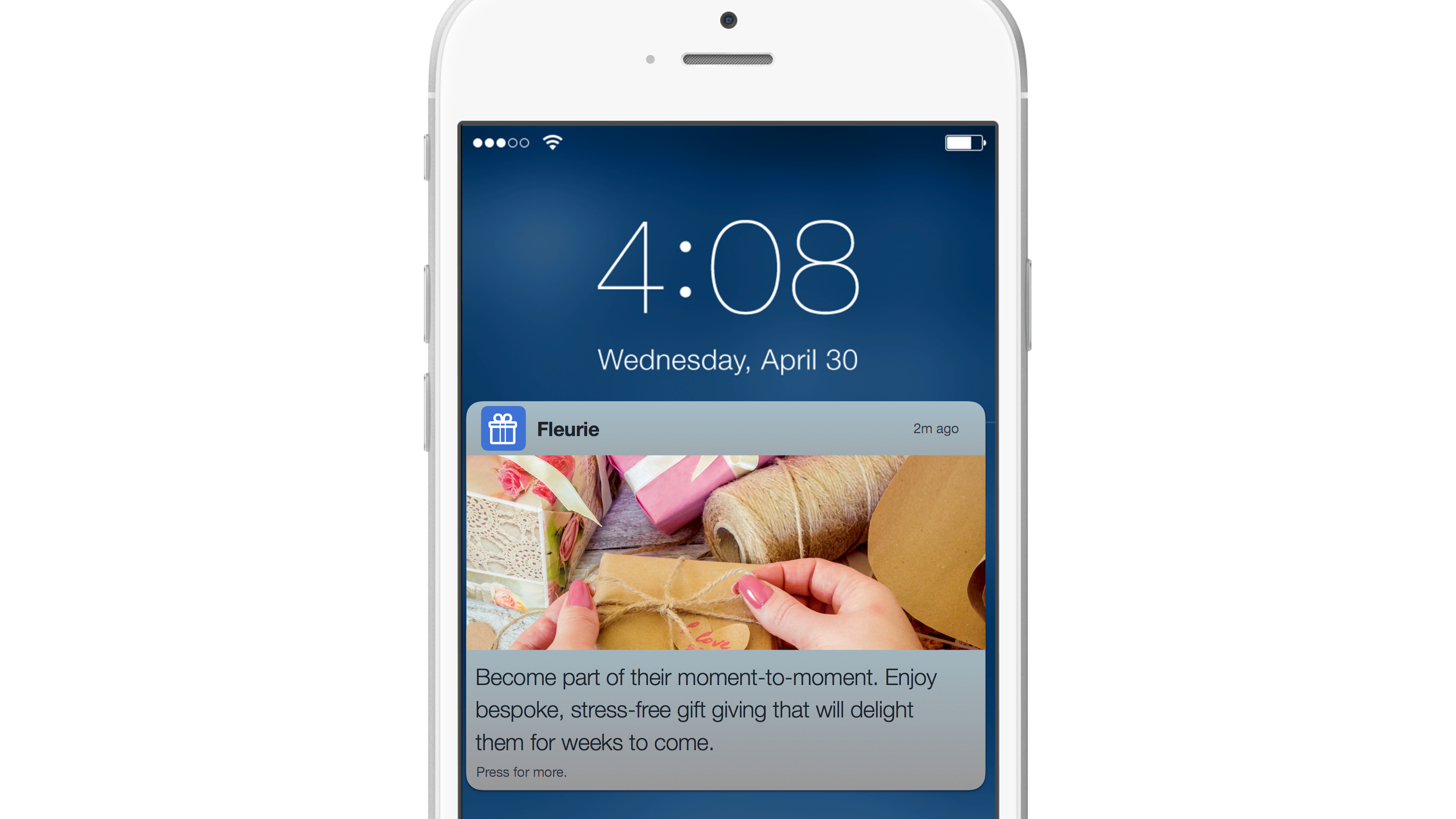 A smartphone screen displaying the time and date, with a notification from an app featuring a photo of gift-wrapping materials and a hand.