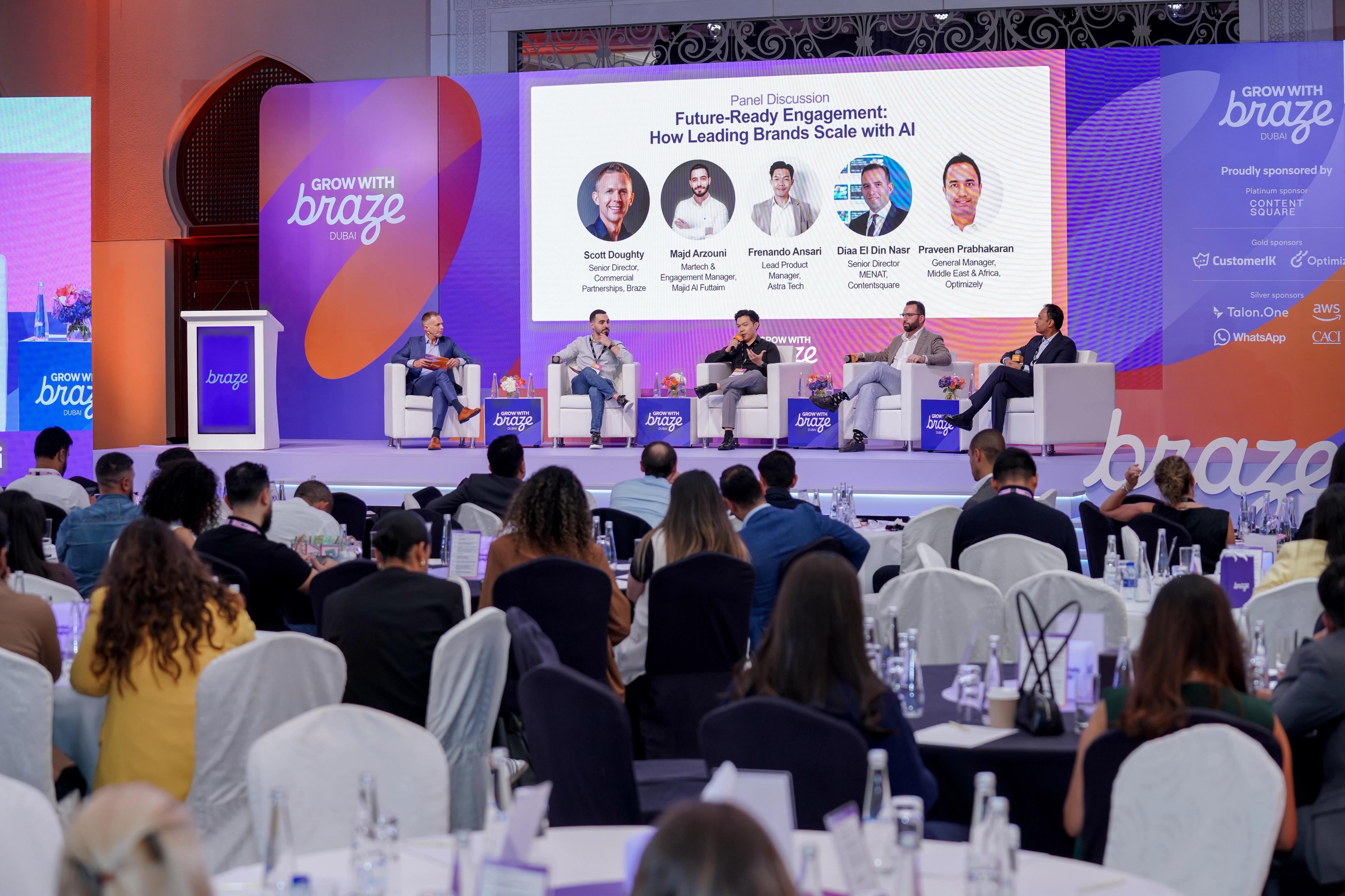 Panel discussion on "Future-Ready Engagement with AI" at the "Grow with Braze" event, with five panelists on stage and an audience.