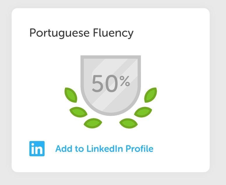 A badge indicating 50% fluency in Portuguese, surrounded by green leaves. There is an option to add this achievement to a LinkedIn profile.