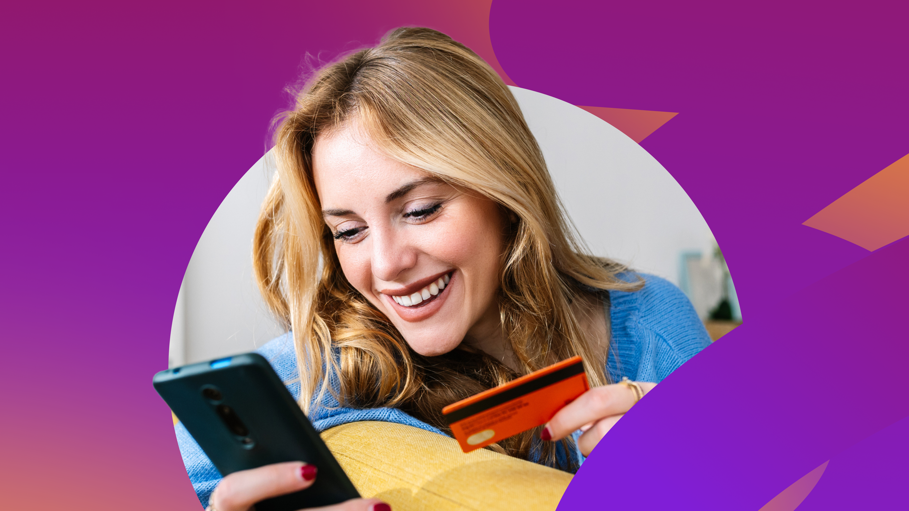 a woman is smiling while holding a credit card and looking at her phone