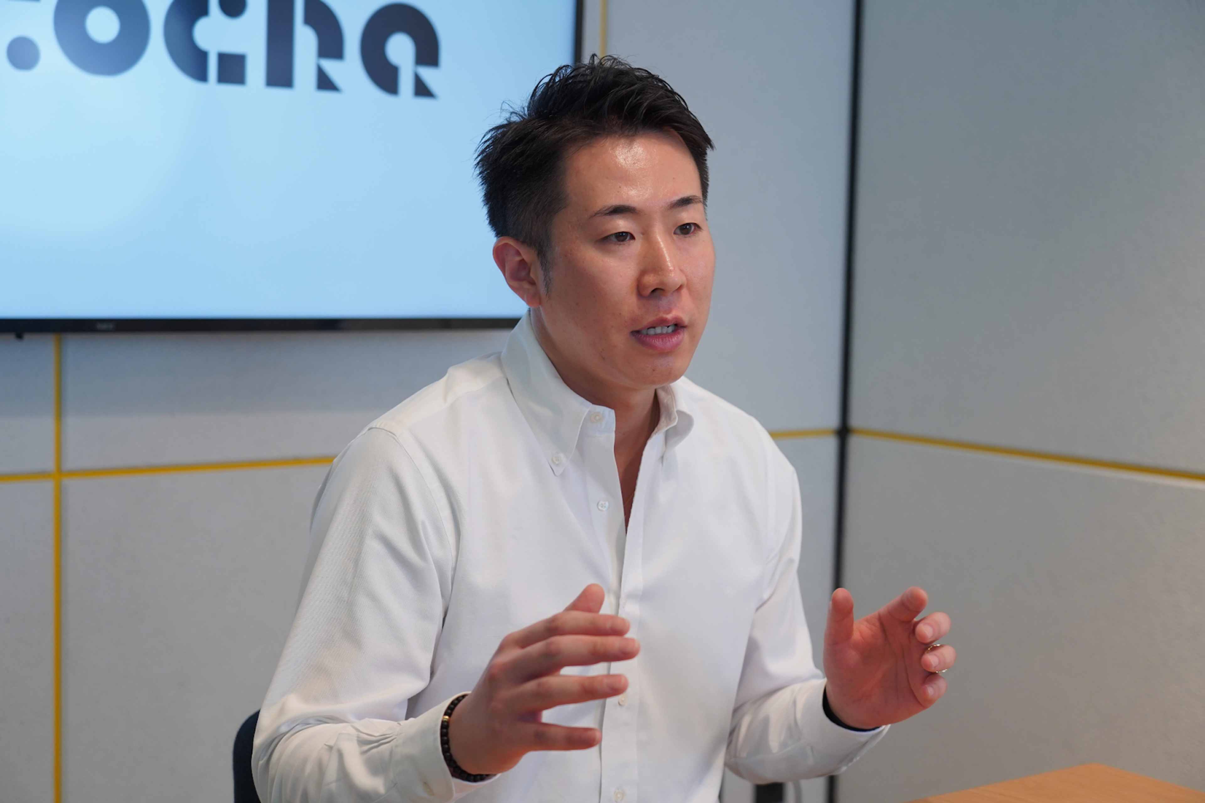 a man talking in front of a screen that says ocho