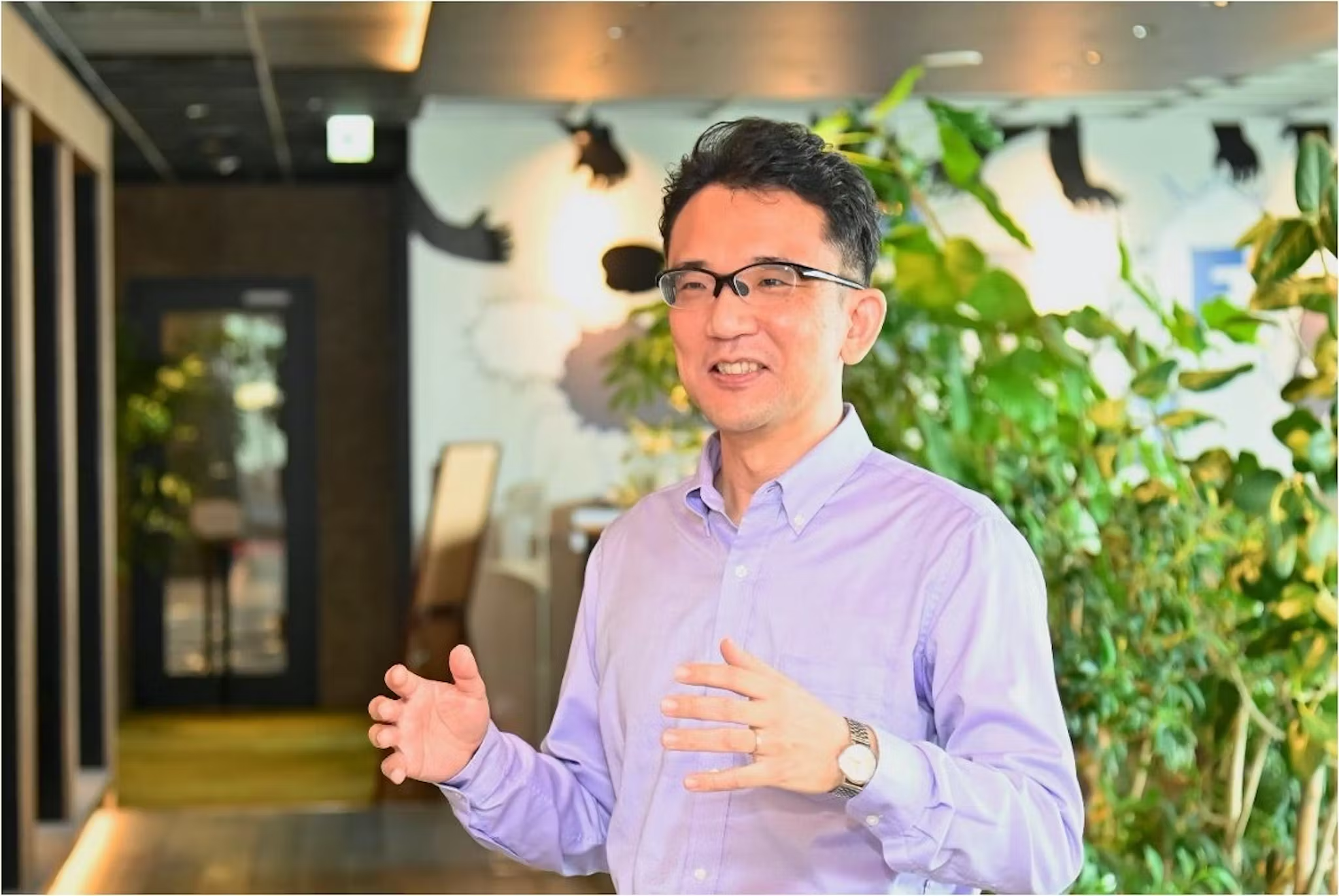 a man wearing glasses and a purple shirt is talking