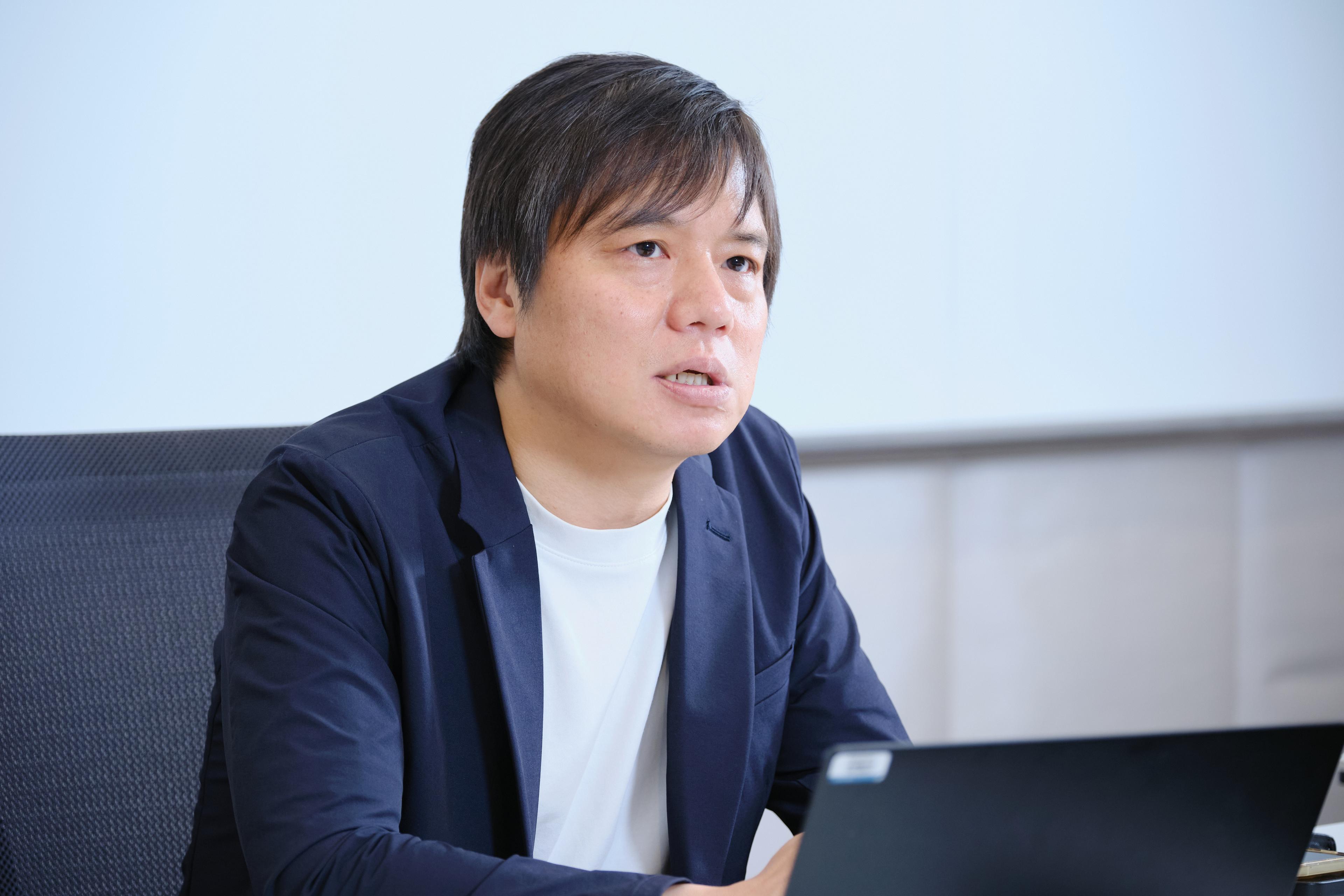 a man in a suit is sitting in front of a laptop computer .
