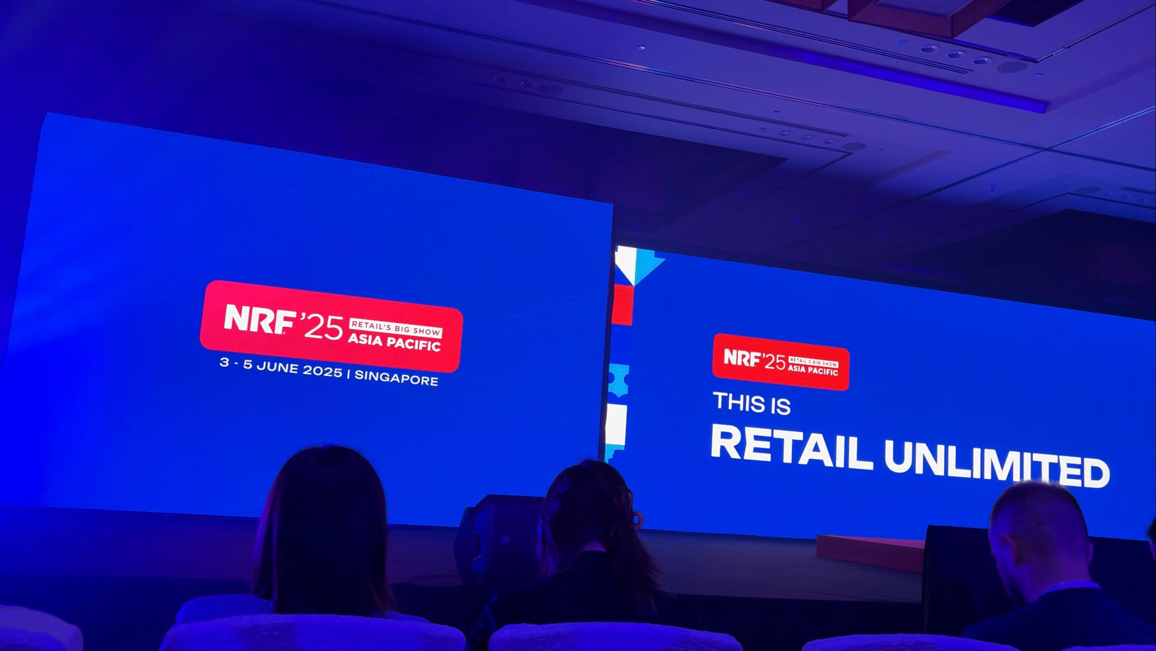 a group of people are sitting in front of a large screen that says `` this is retail unlimited '' .