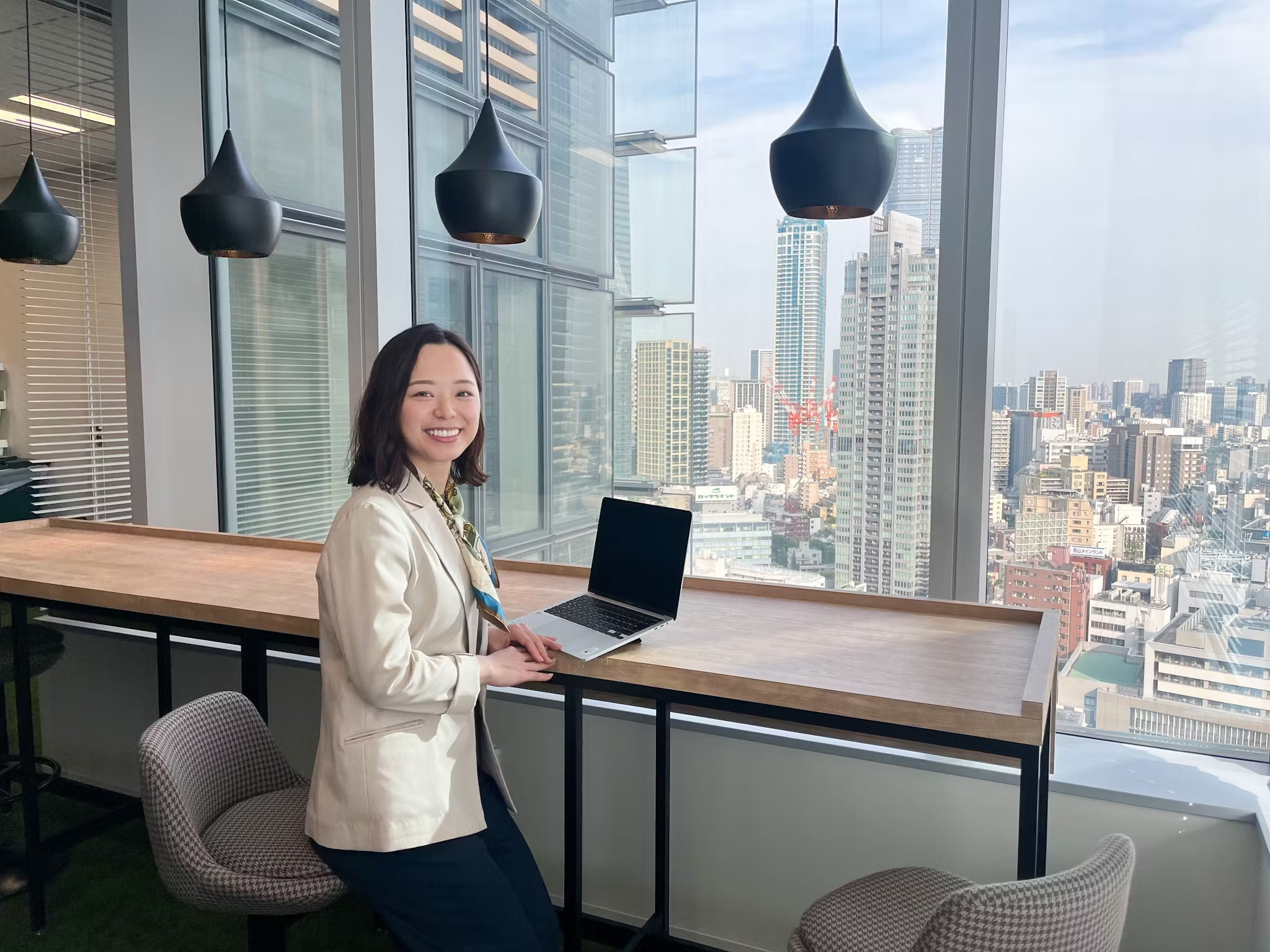 a woman sitting at a table with a laptop on it