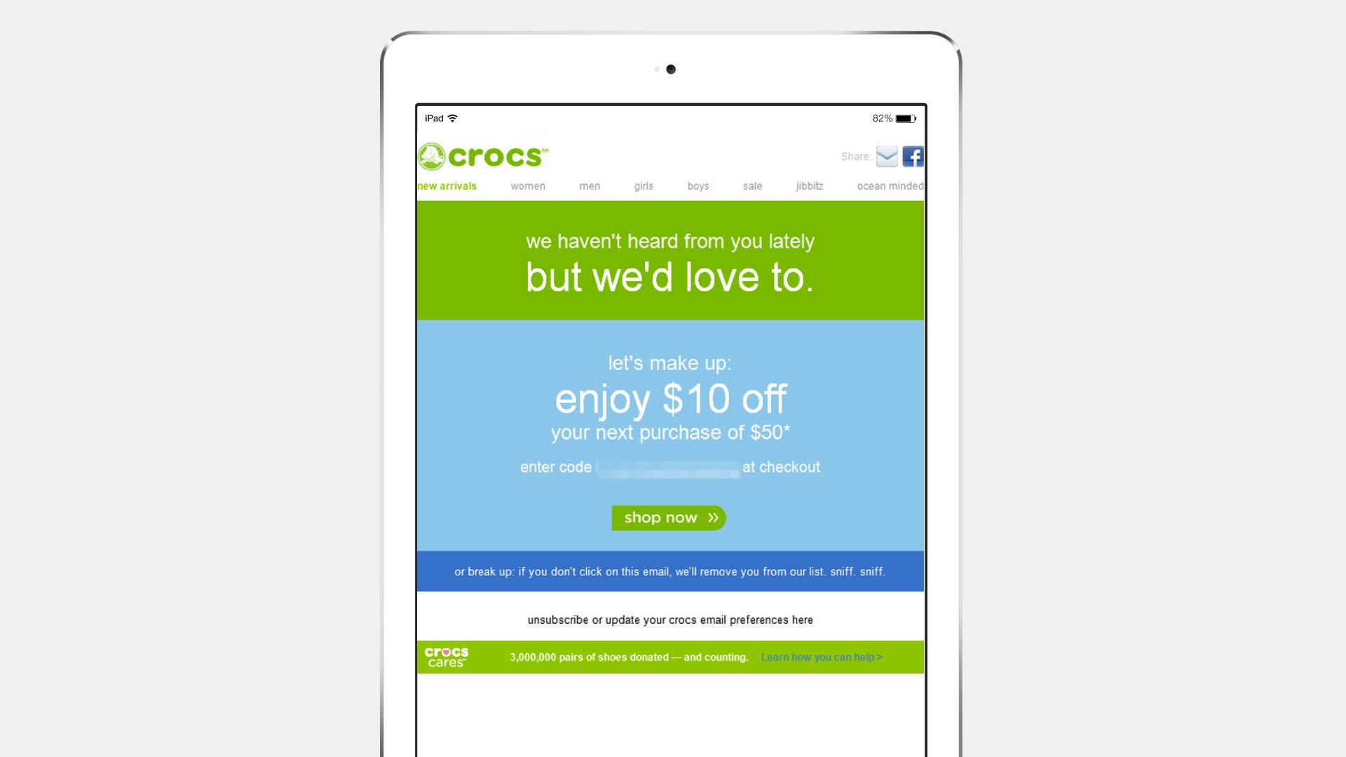 A tablet displaying a Crocs promotional webpage offering $10 off the next purchase of $50. The message invites users to enter a code at checkout.
