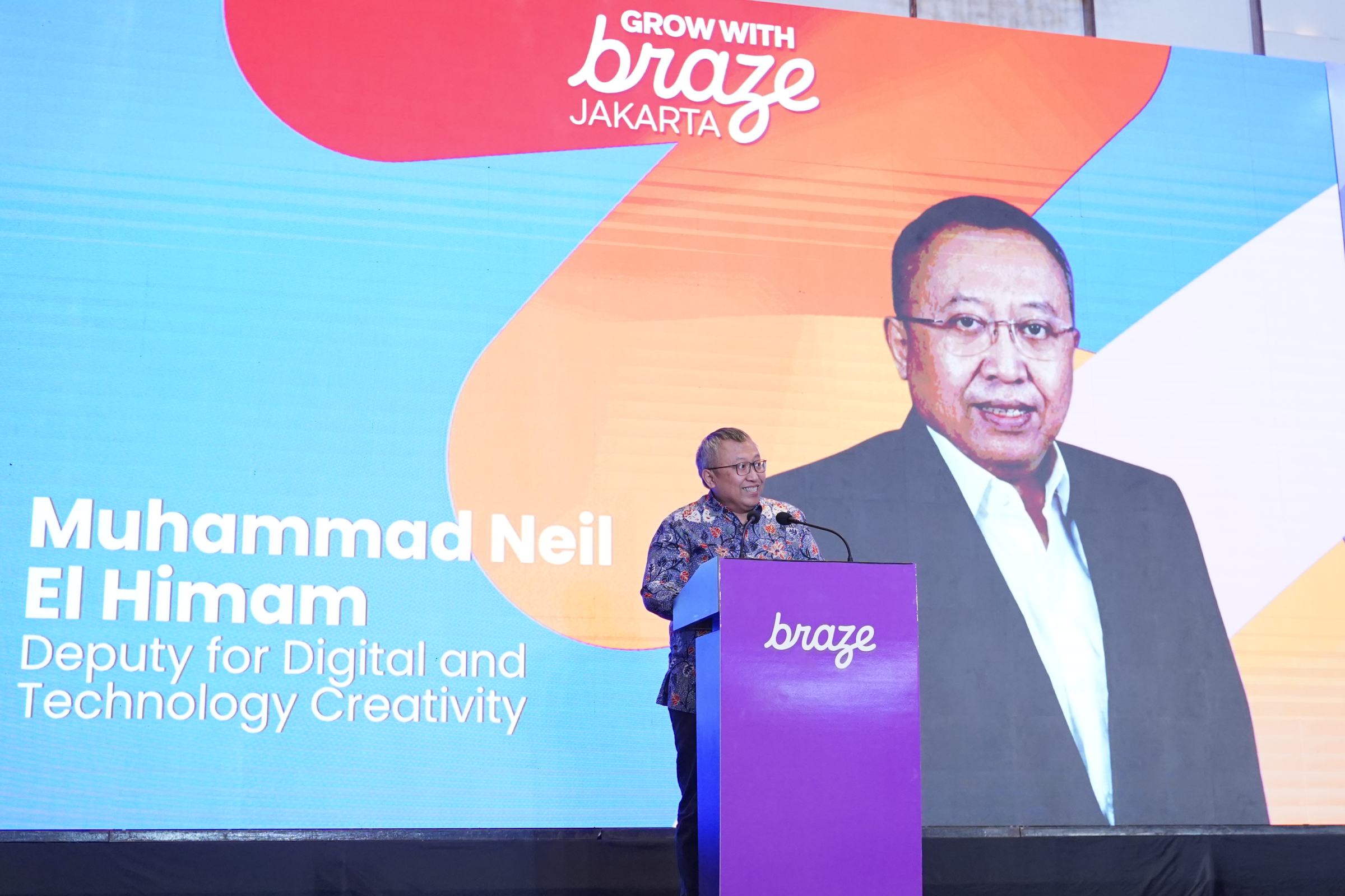 Muhammad Neil El Himam, Deputy for Digital and Technology Creativity, speaks at a podium during Grow With Braze Jakarta.