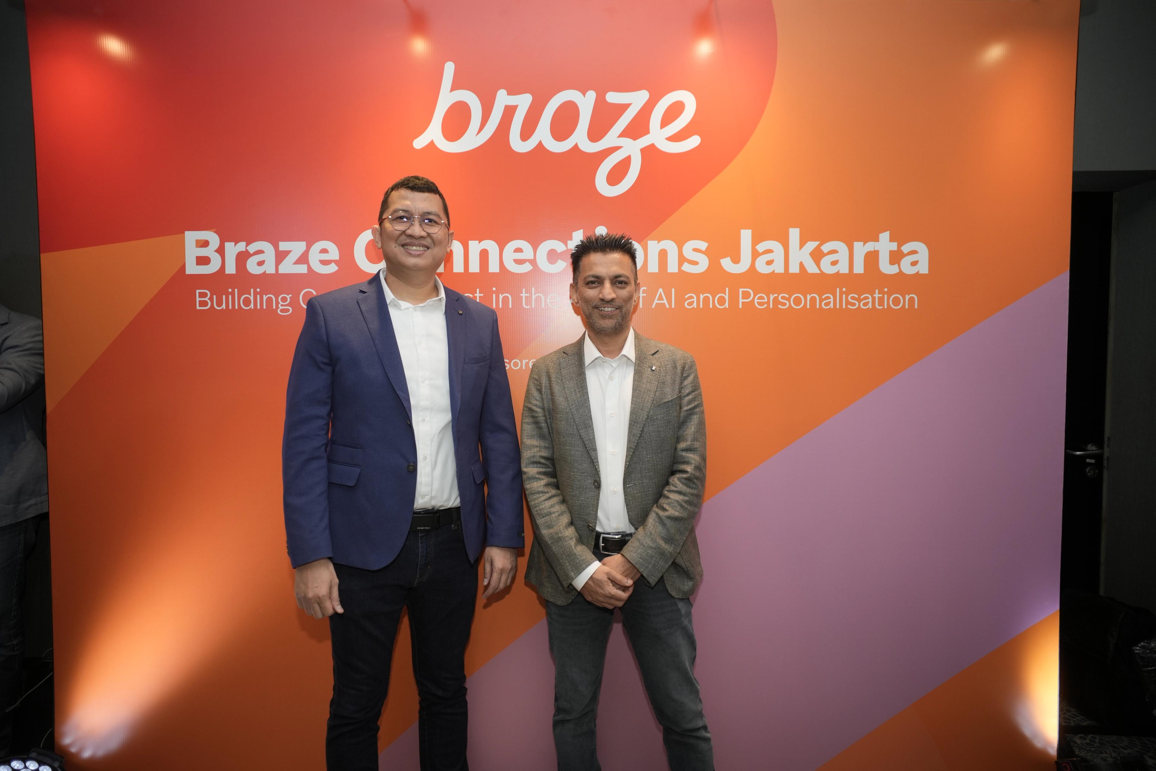 two men in suits are standing next to each other in front of a wall .