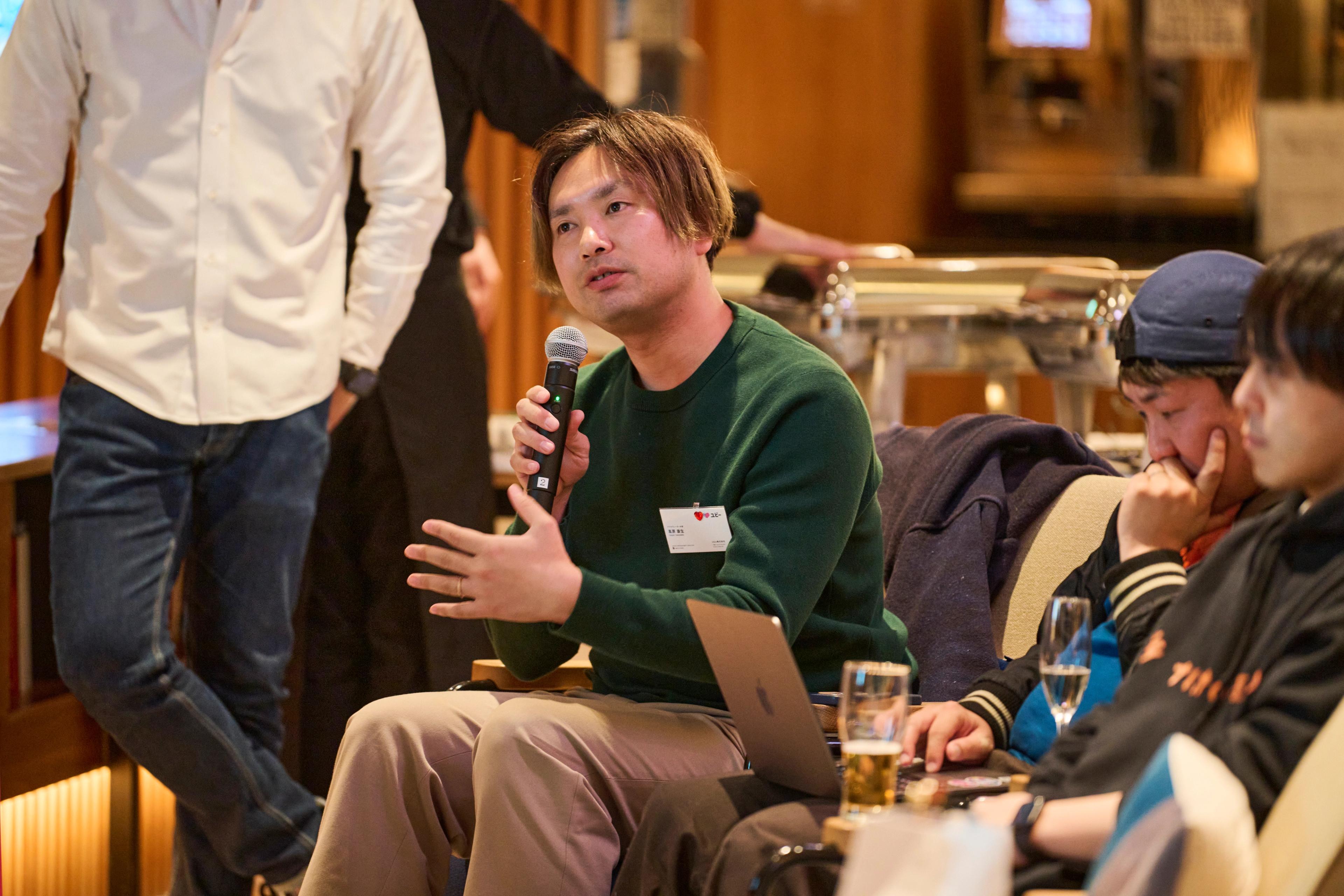 a man is sitting in a chair holding a microphone .