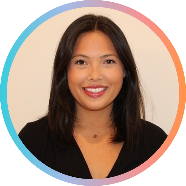 A woman with long, dark hair smiles at the camera. She is wearing a black top and has a circular, colorful border around her image.