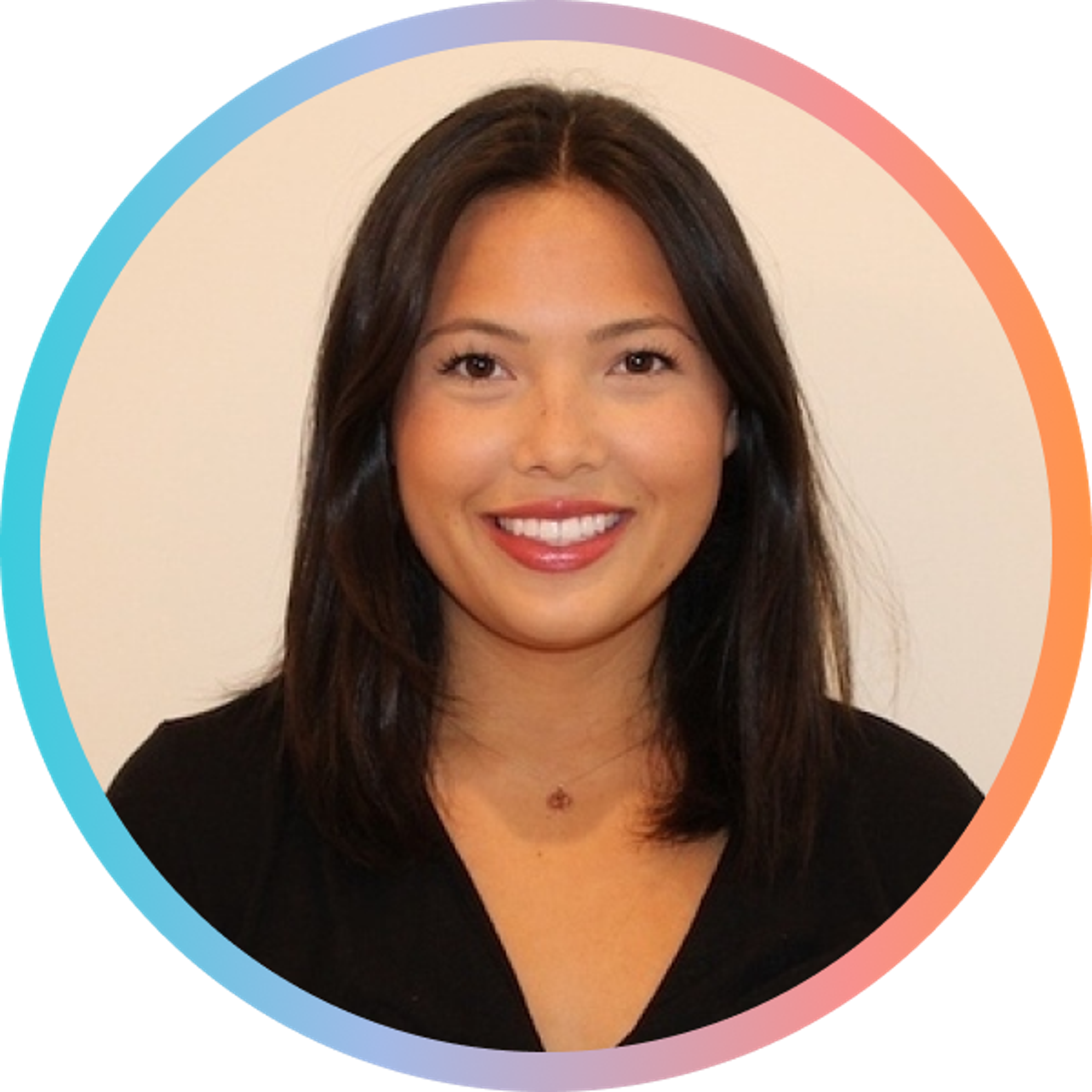 A woman with long, dark hair smiles at the camera. She is wearing a black top and has a circular, colorful border around her image.