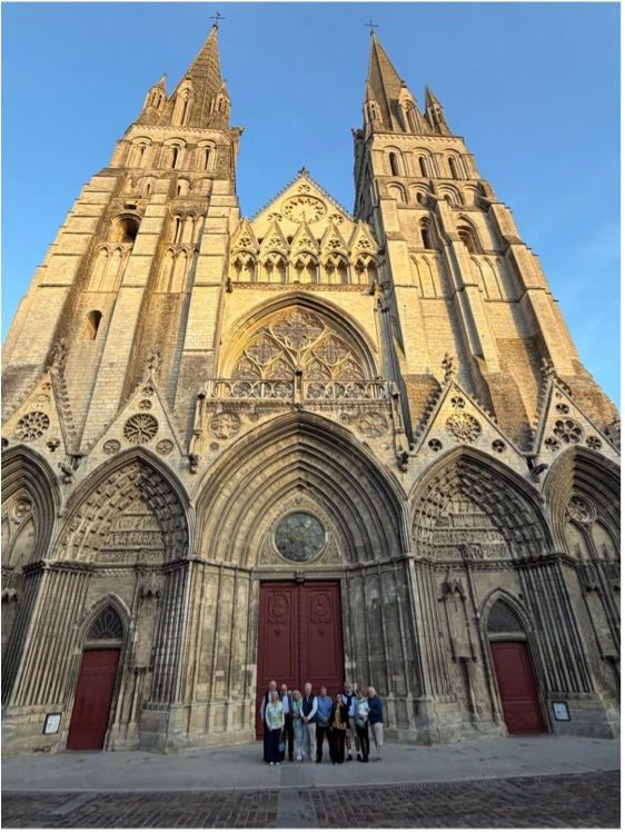 Members of the Distillers’ Car Club standing in front of the west front of Bayeux Cathedral