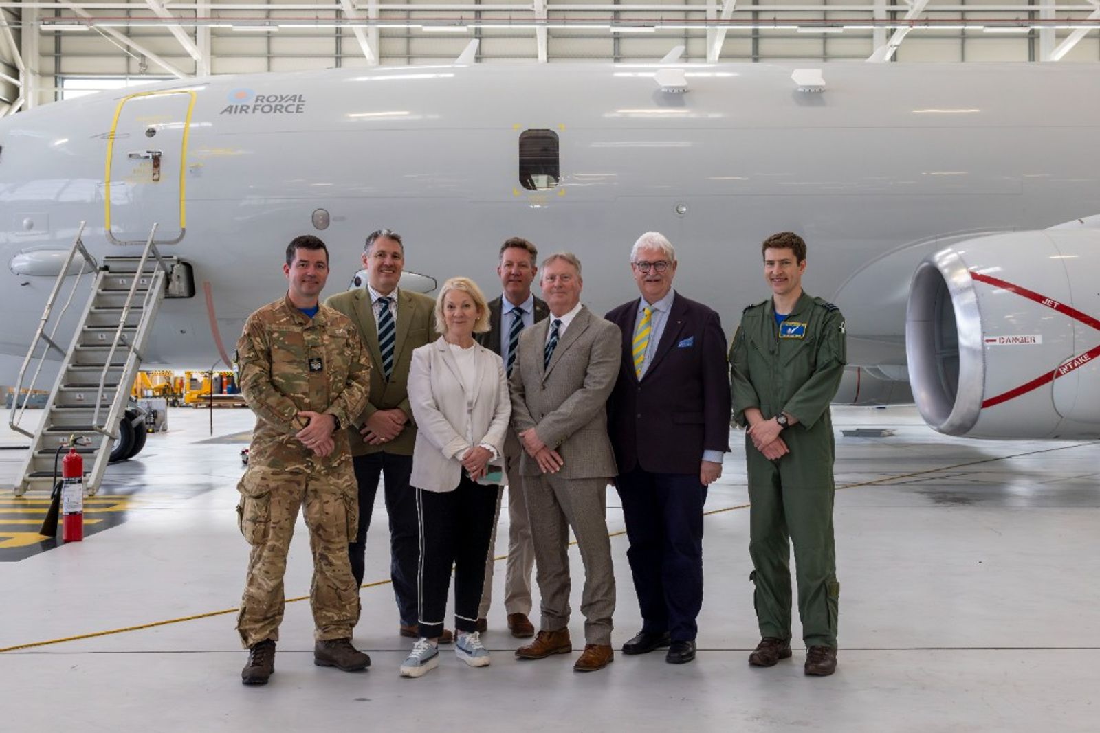 Distillers’ Company members with 42 Squadron personnel in front of a Royal Air Force aircraft.