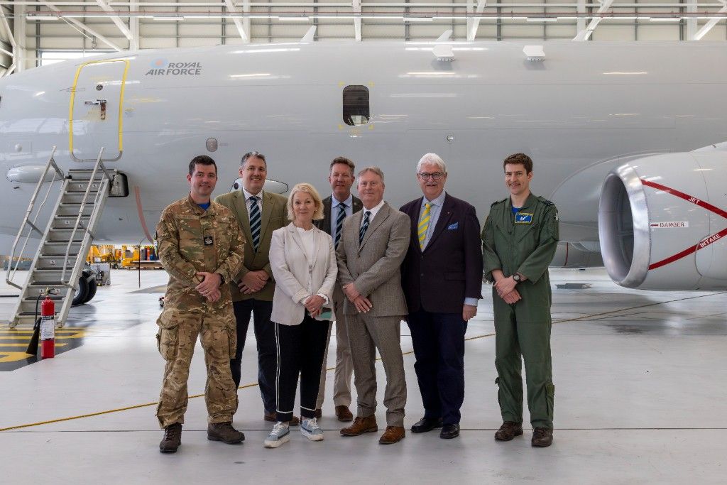 Distillers’ Company members with 42 Squadron personnel in front of a Royal Air Force aircraft.