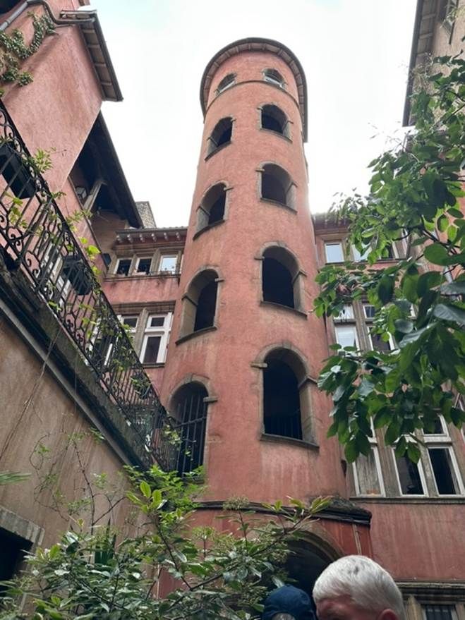 A pink stair tower in a Lyon traboule