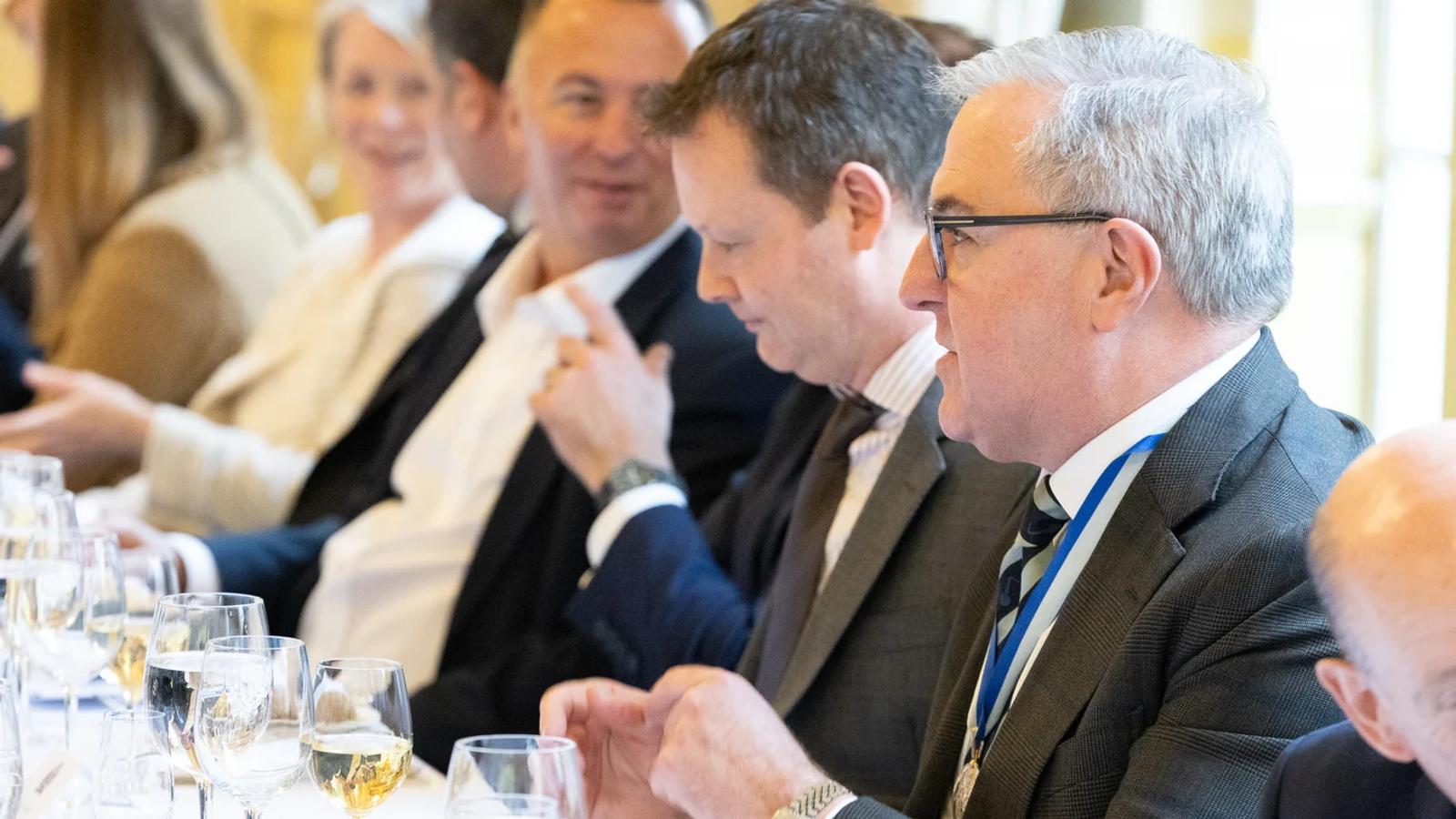 Company members seated at a formal lunch.