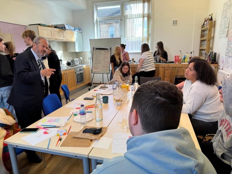 Daniel Szor talking with young people around a table in a training kitchen