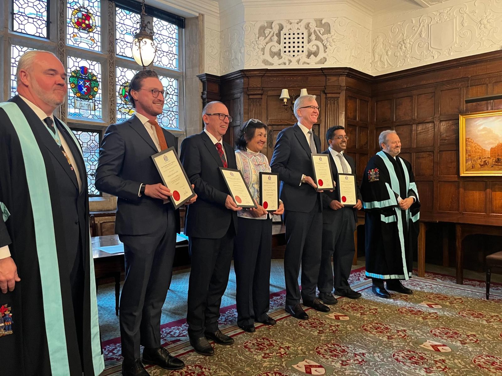 Newly admitted Freemen holding their certificates after the 2026 ceremony.