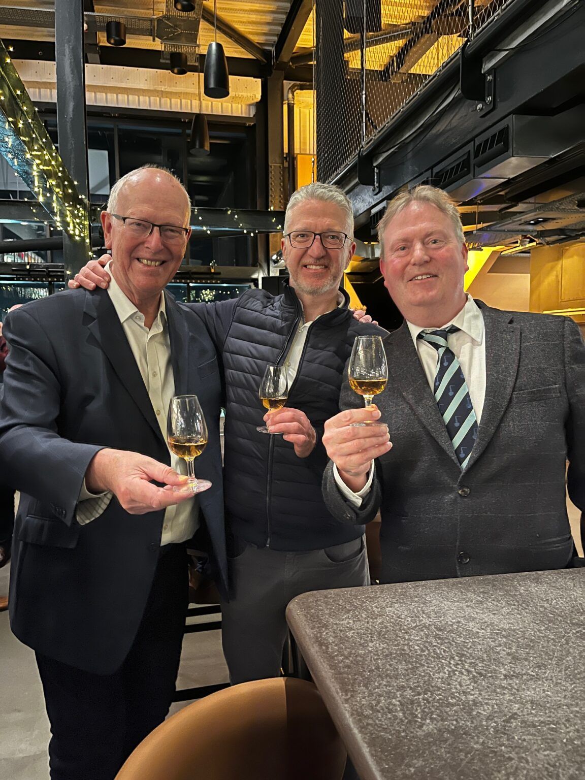 Three men toasting with whisky glasses