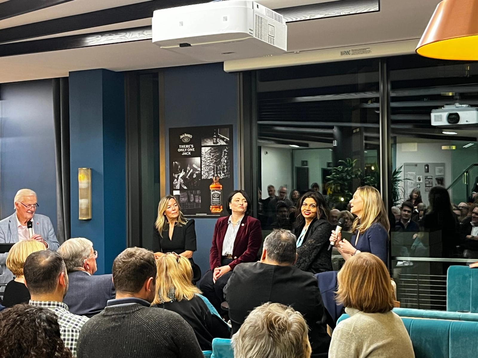 A panel of four speakers addressing a seated audience at the Marketors’ “Be in the Conversation” debate.