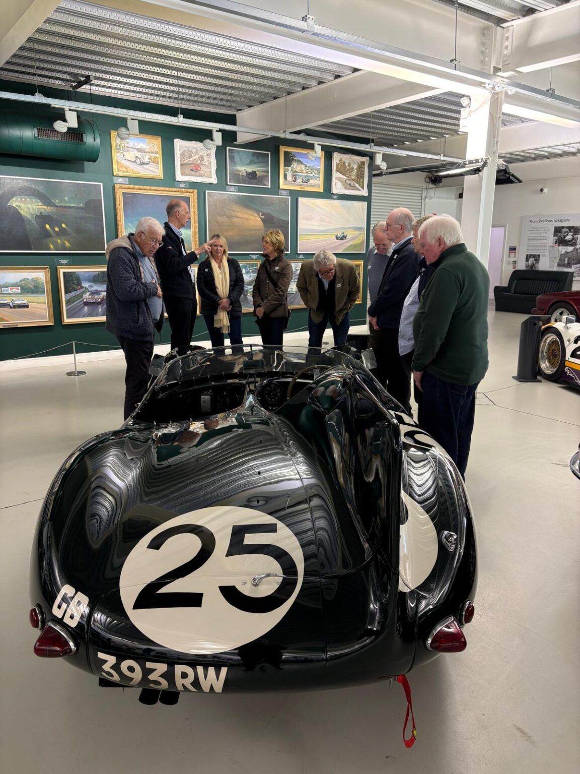 The Distillers Car Club around a Jaguar D-type, number 25, at the British Motor Museum