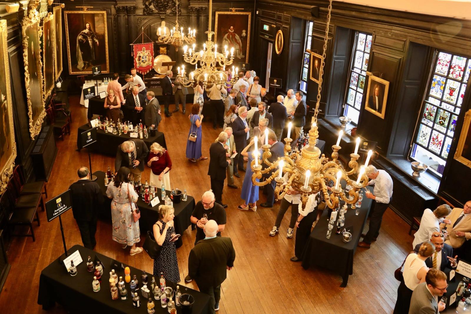 Members tasting spirits at tables during a Company education event.