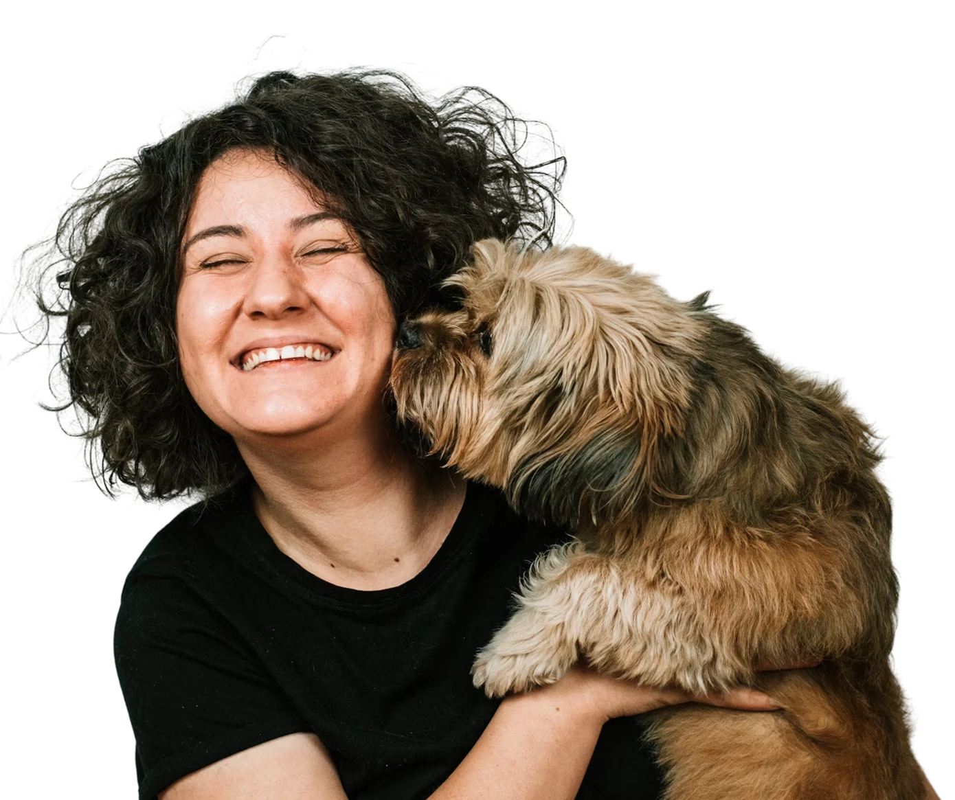 A smiling groomer holding a small dog that is nuzzling her cheek