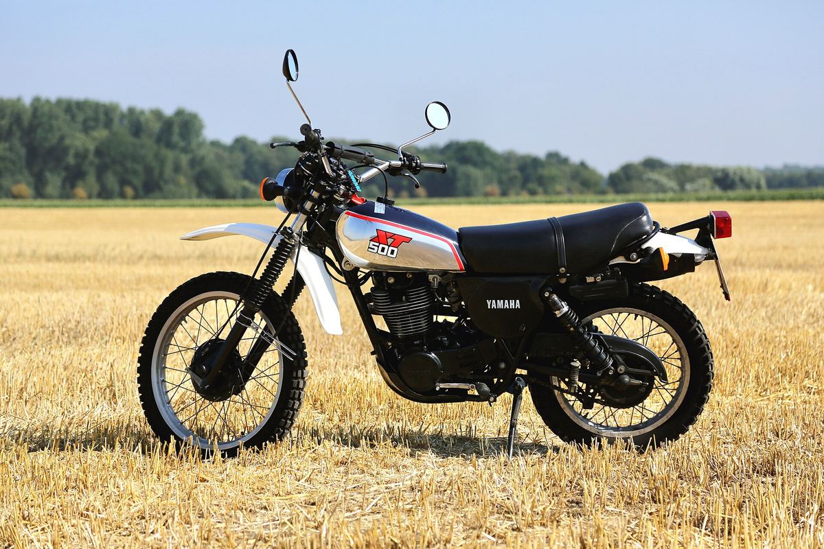 Blue and white 1986 Yamaha XT500 type 1U6 standing in a harvested field under a clear sky