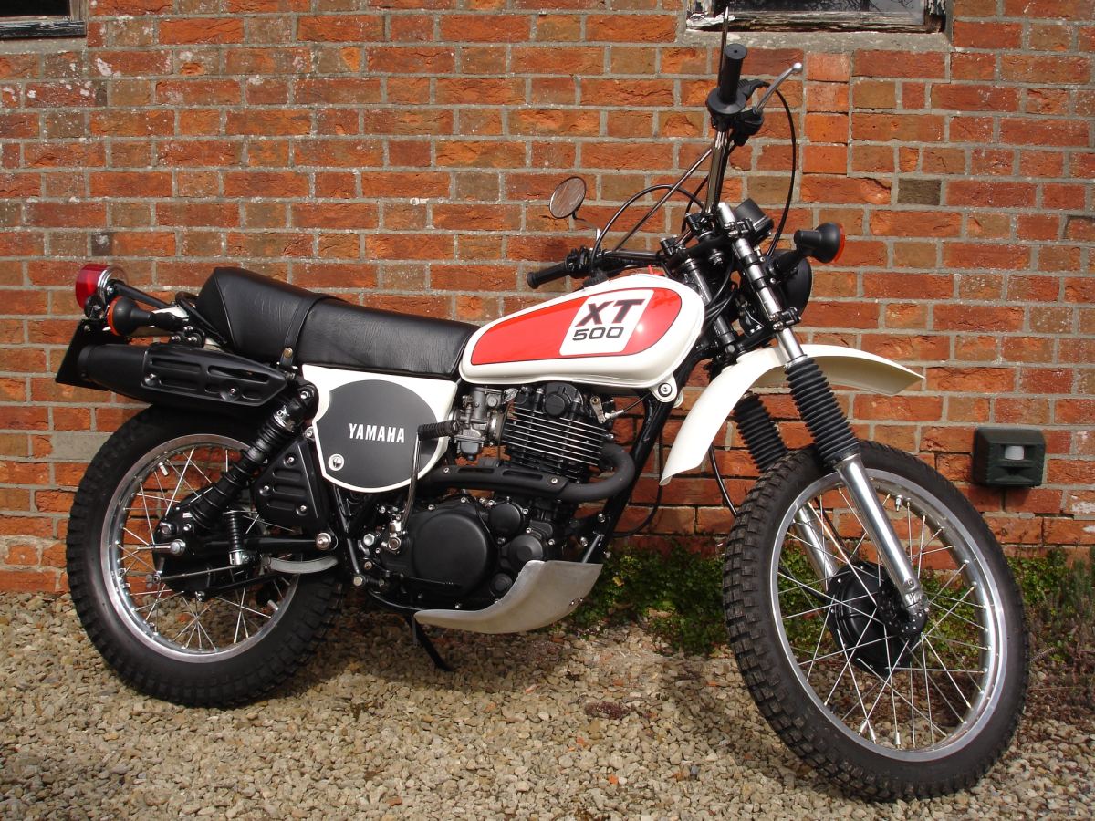 White and red Yamaha XT500 restored to original specification, parked side-on against a brick wall