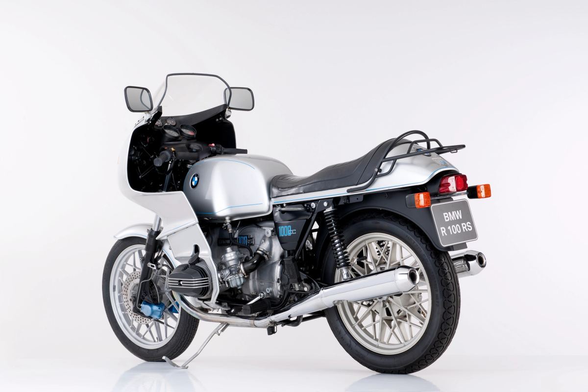 Silver 1976 BMW R 100 RS photographed by BMW in a white studio, rear three-quarter view