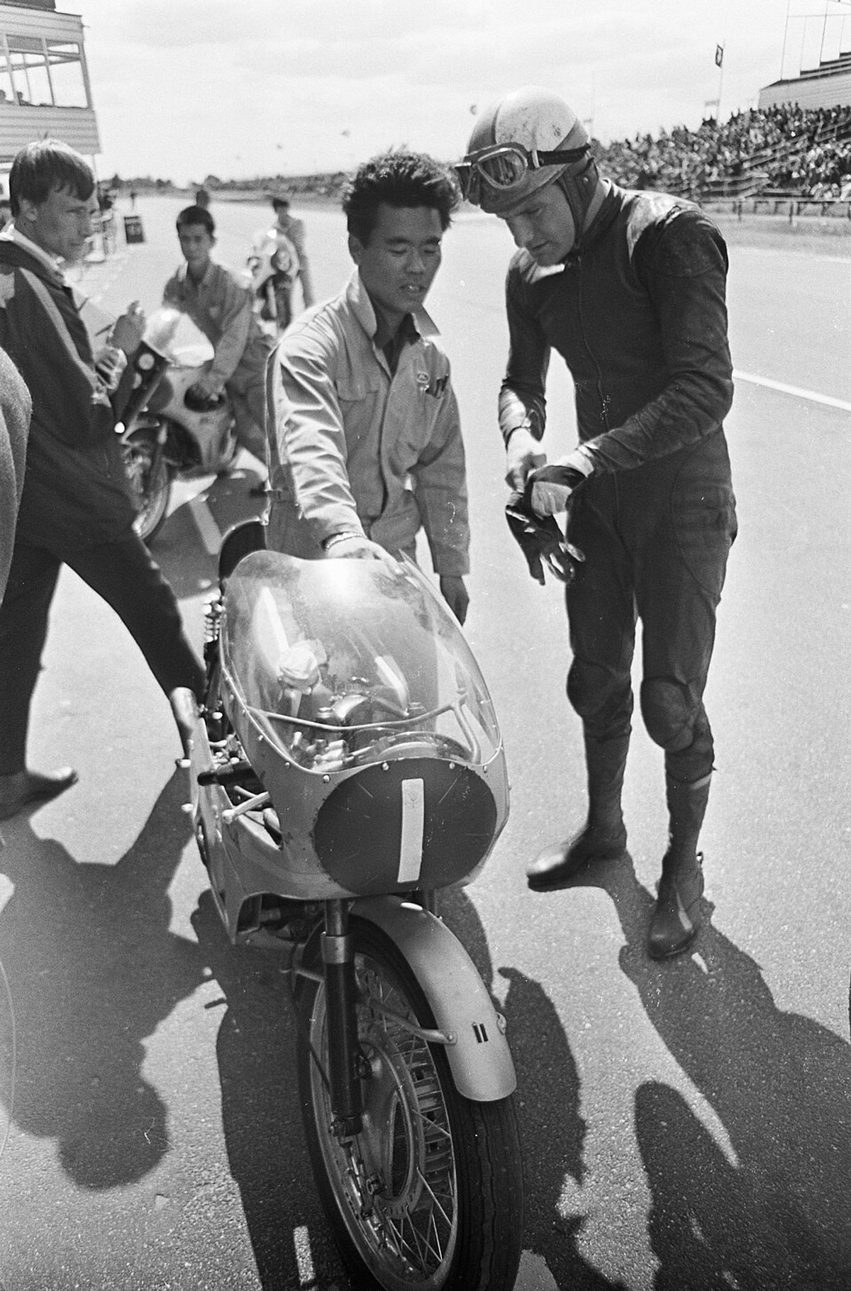 Mike Hailwood in the pits at Assen with a Japanese Honda mechanic, 1967