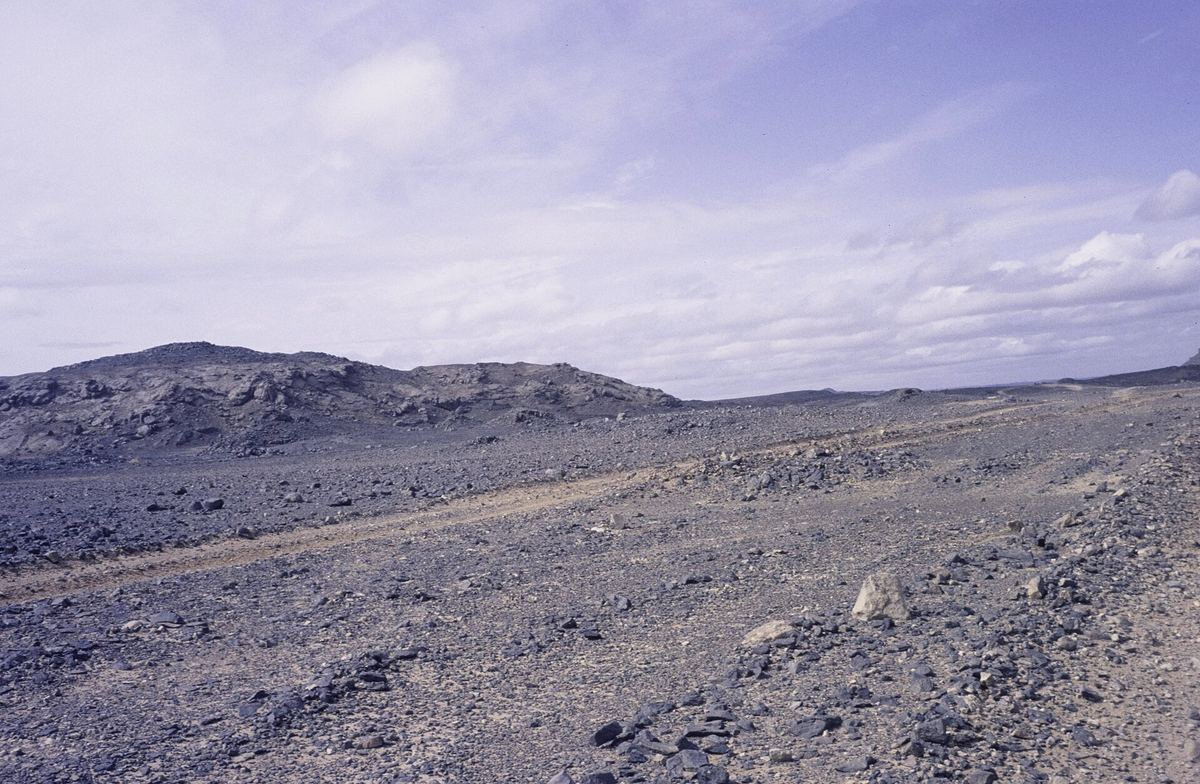 Stony desert track through the Ahaggar region of southern Algeria under a cloudy sky