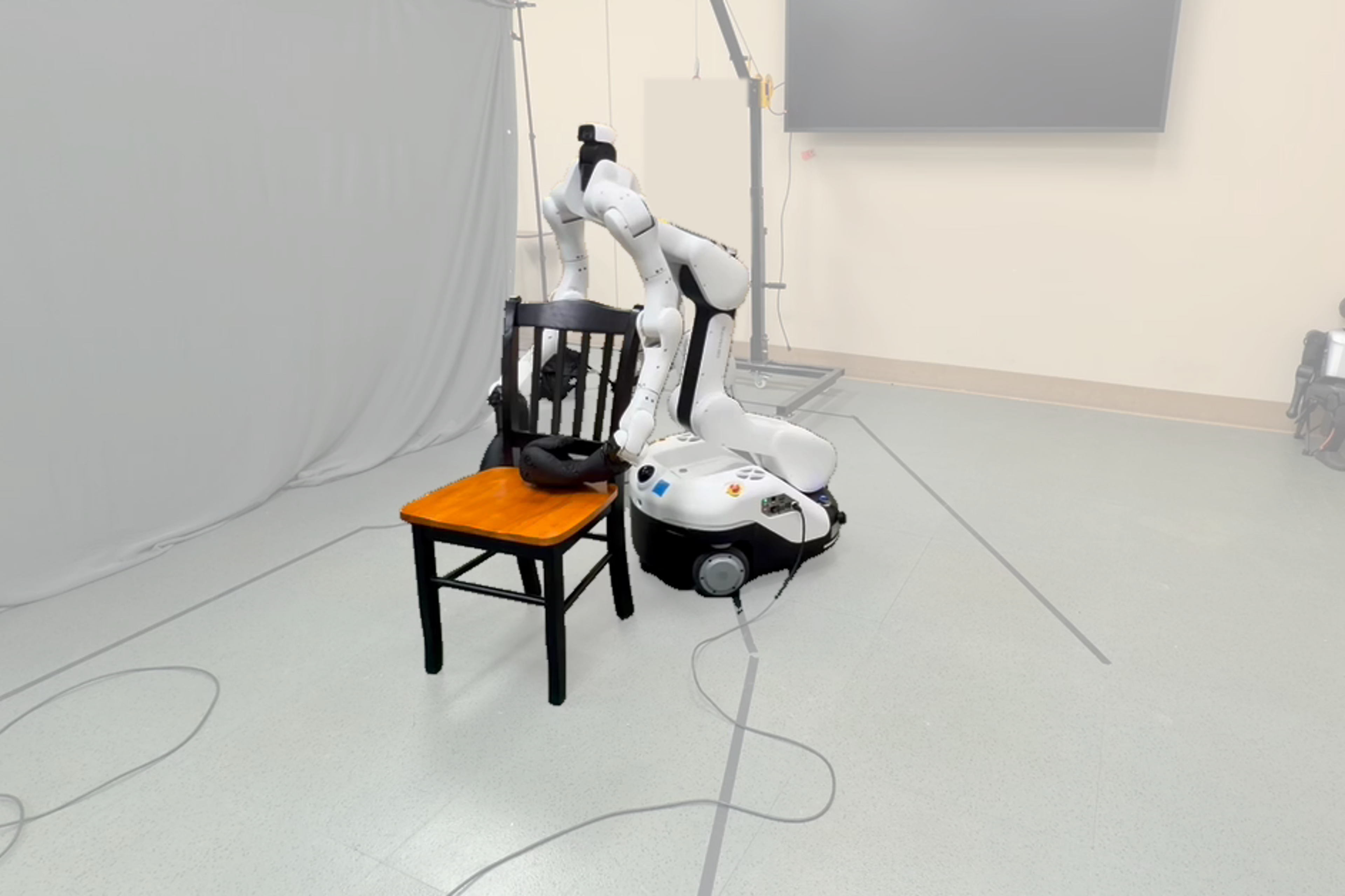 A Dexmate Vega relocates a chair, one of InterMimicGen's real-robot deployments (Figure 1 of the paper).