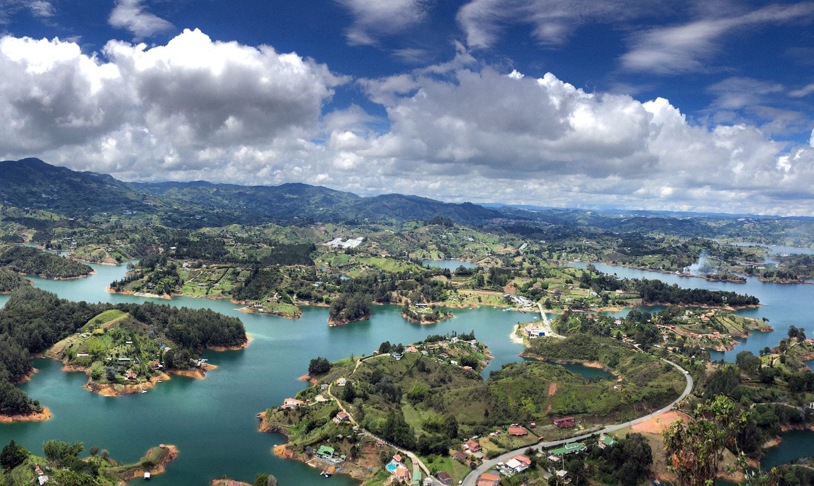 Vista aérea del embalse de Guatapé con aguas turquesas entre montañas verdes