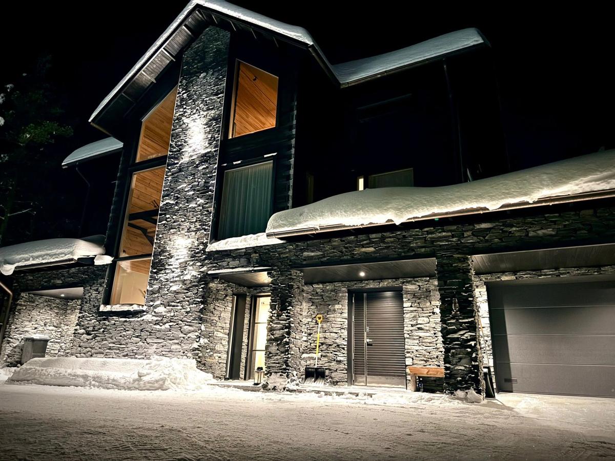 Talvinen kuva jossa luonnonkivestä rakennettu huvilan julkisivu Suomen Lapissa.