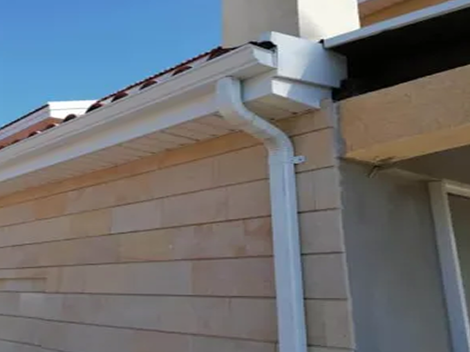 White seamless aluminium gutter on the corner of a house