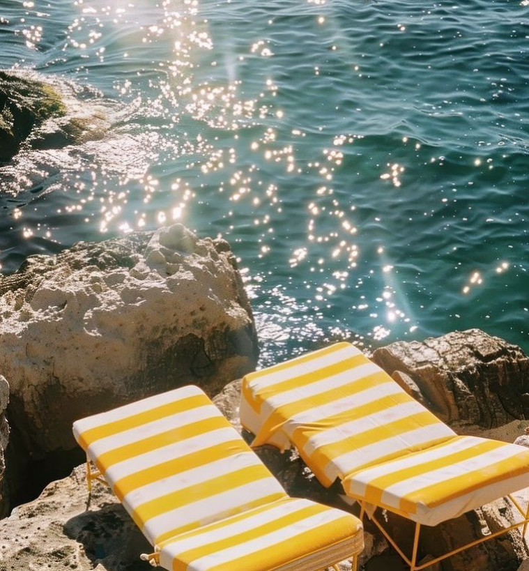Yellow striped sun loungers by the sea