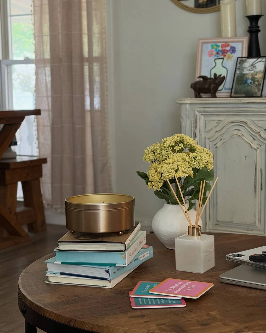 Side table styled with yellow hydrangeas, stacked books and a brass bowl