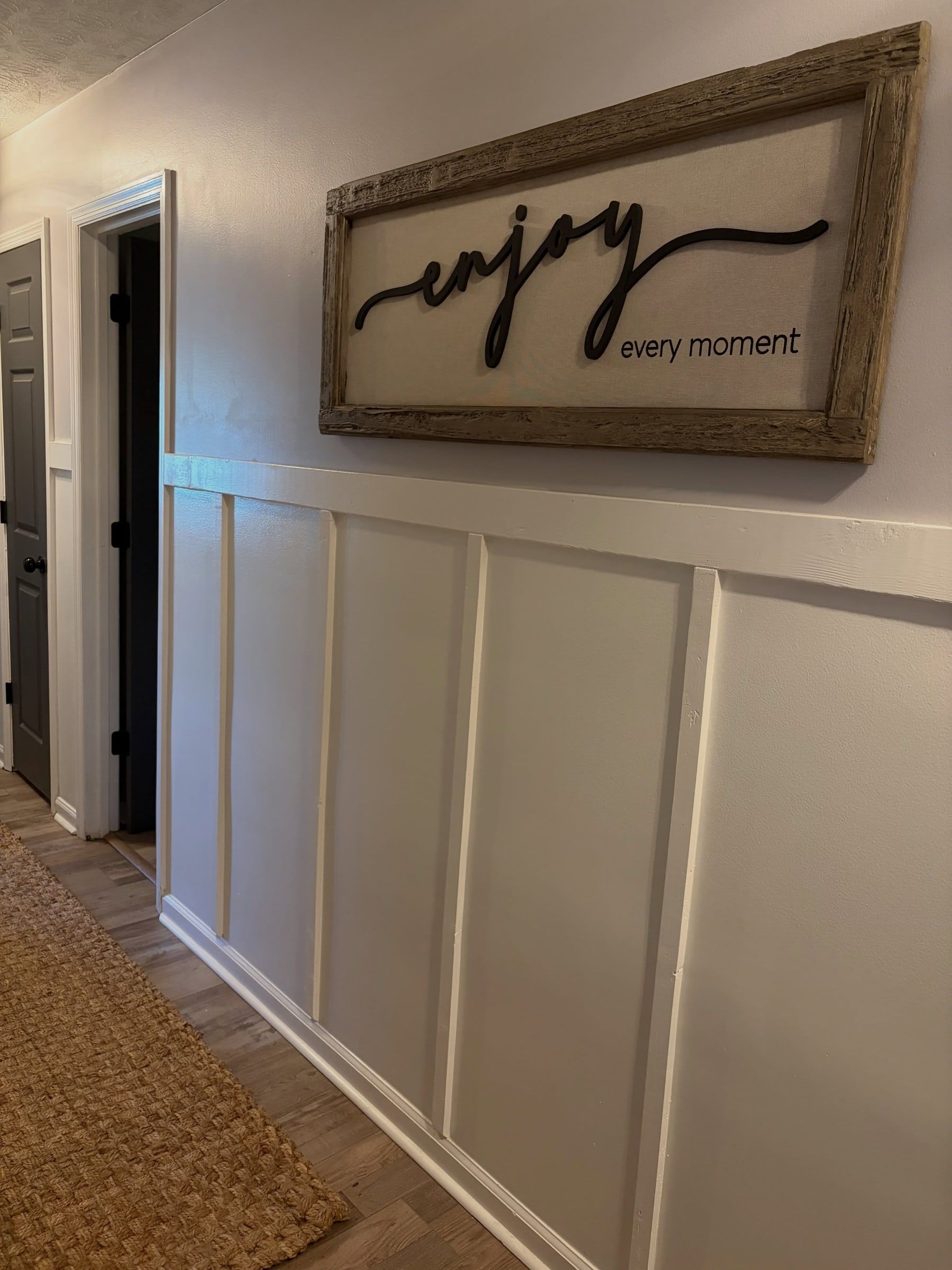 Hallway finished with white board and batten under an "enjoy every moment" sign