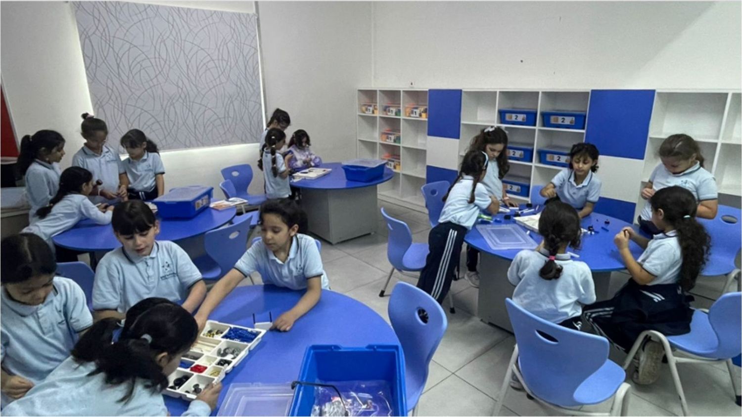 Pupils working in groups at blue tables with their kits