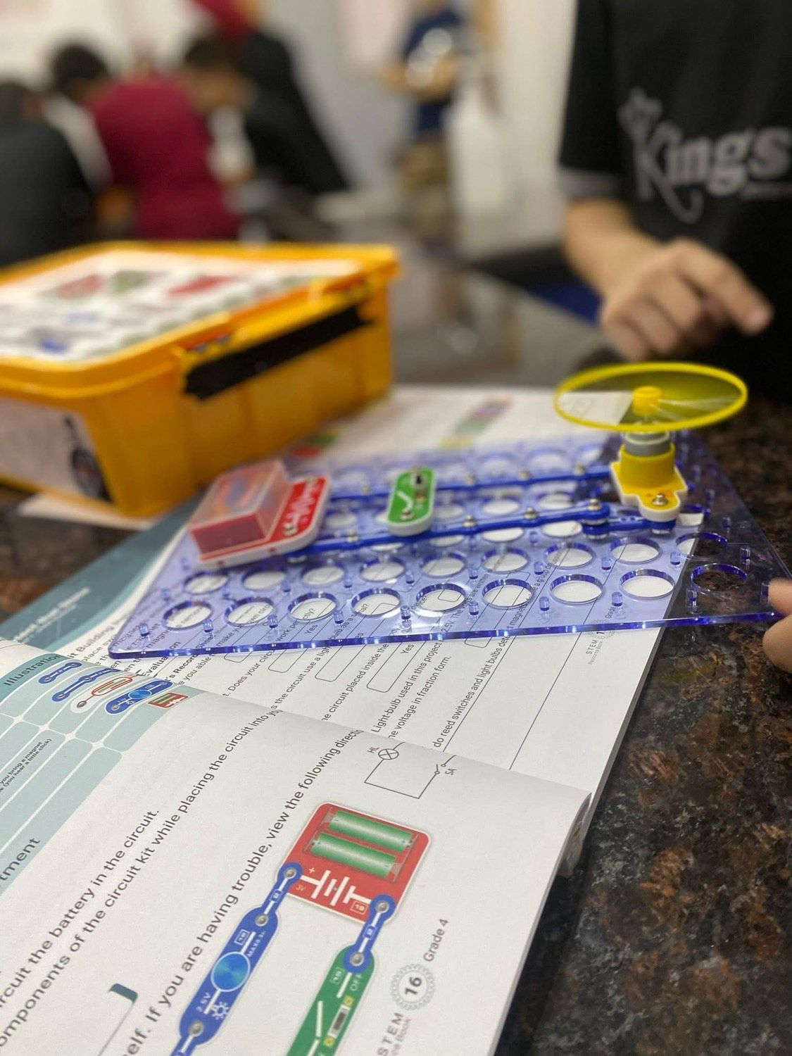Un circuito montado en su placa, junto al libro de trabajo abierto
