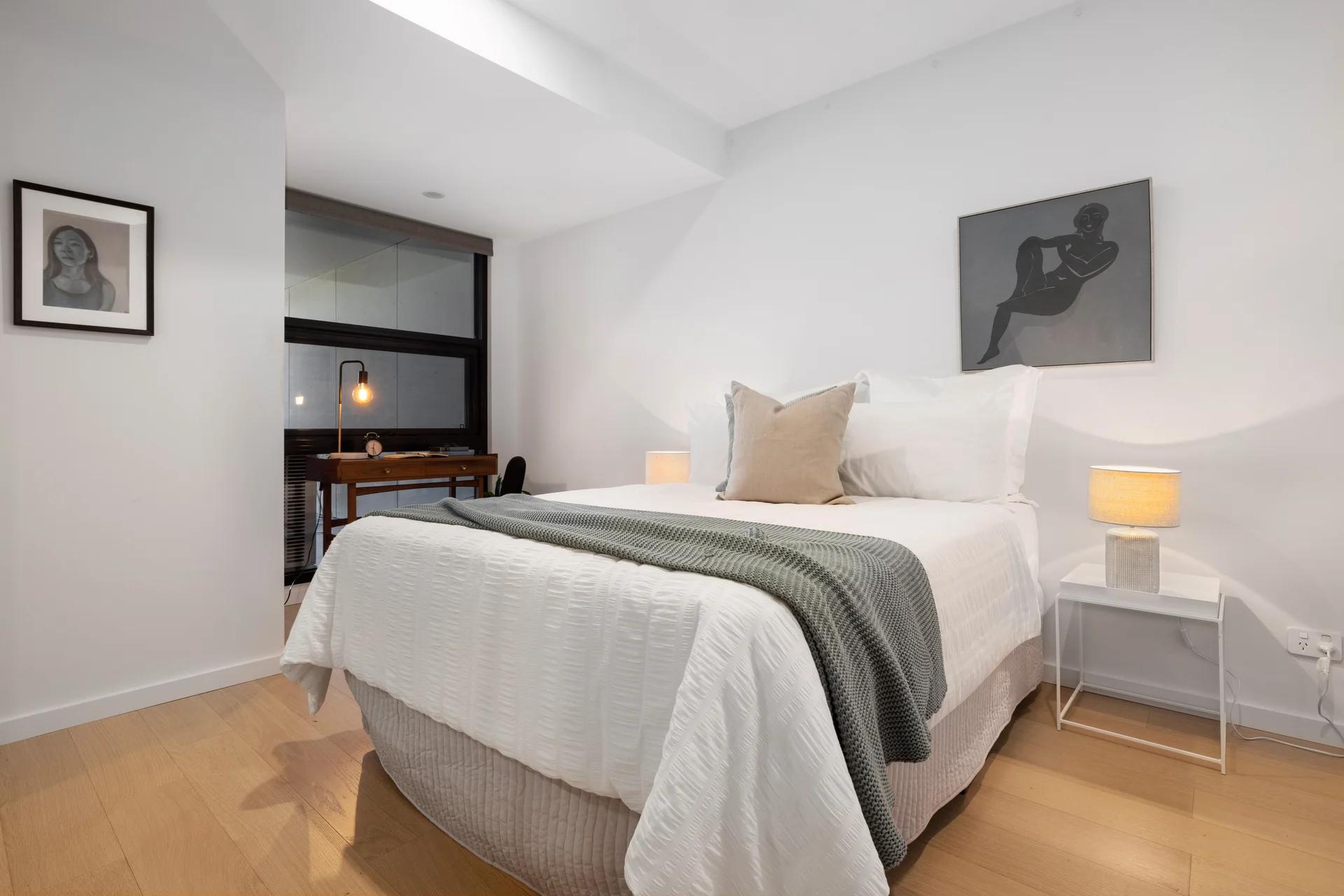 Styled bedroom with neutral bedding, fluffed pillows and clear bedside tables, ready for a real estate photo shoot