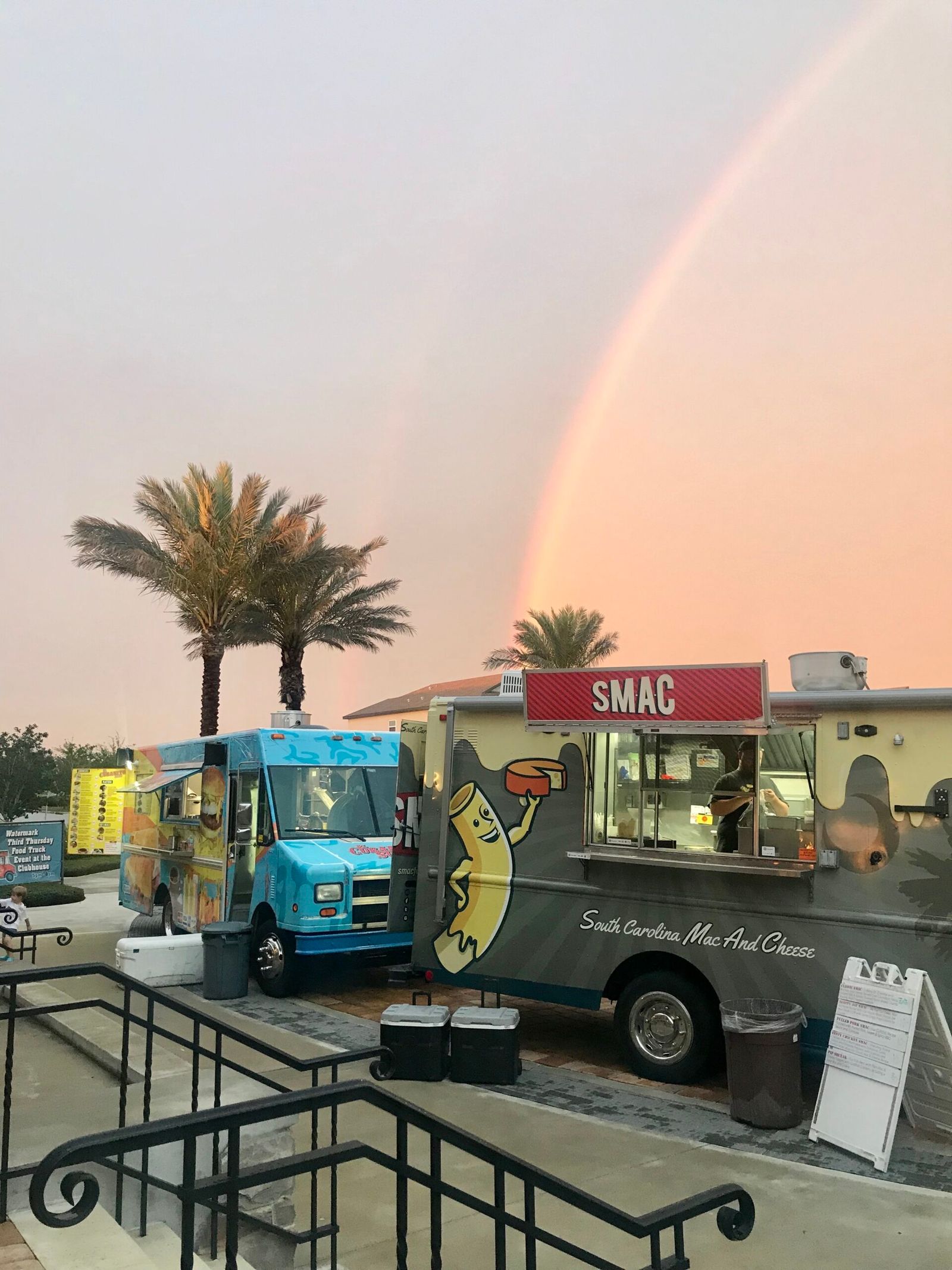 Food trucks under a rainbow sky