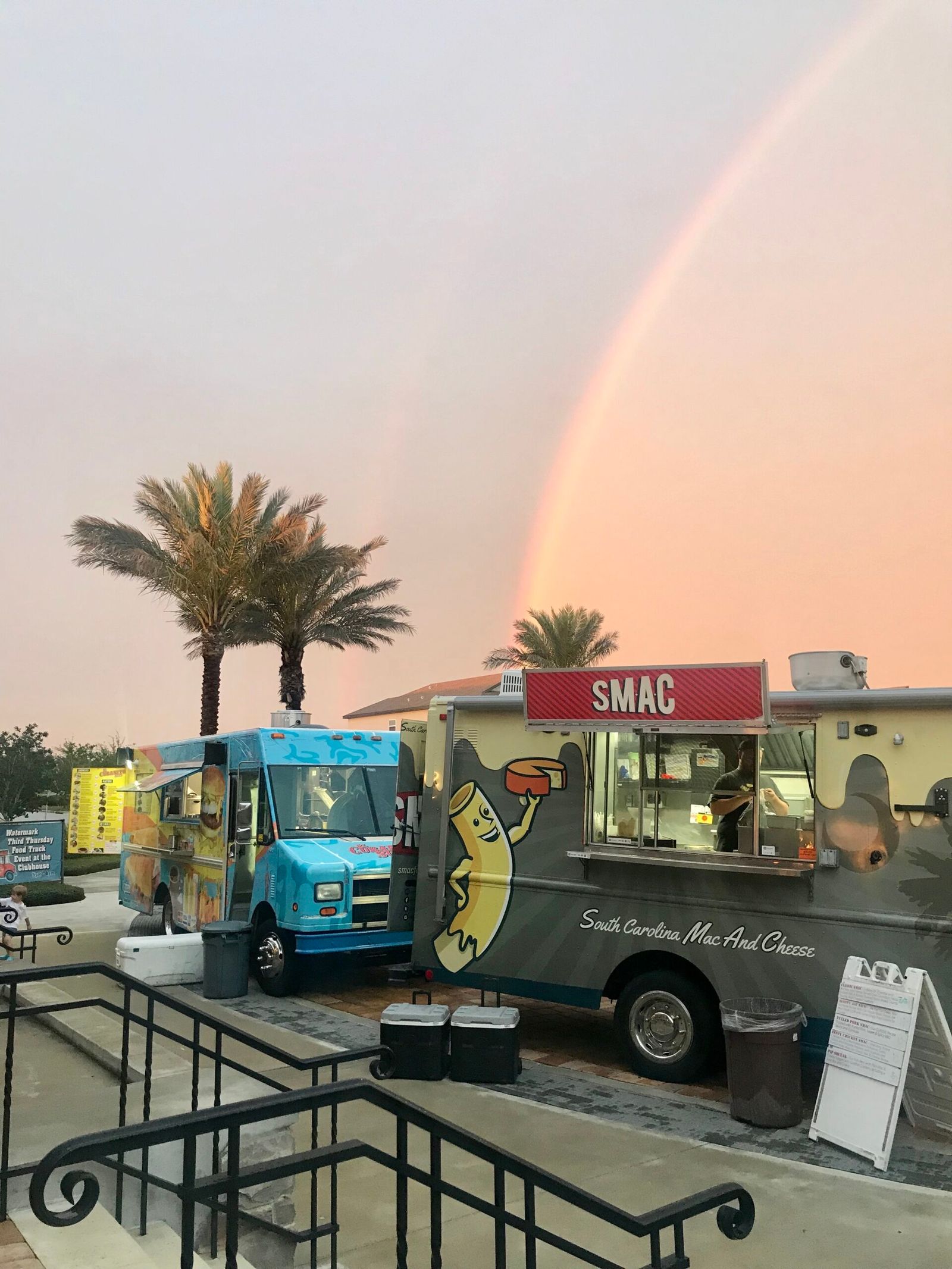 Food trucks under a rainbow sky