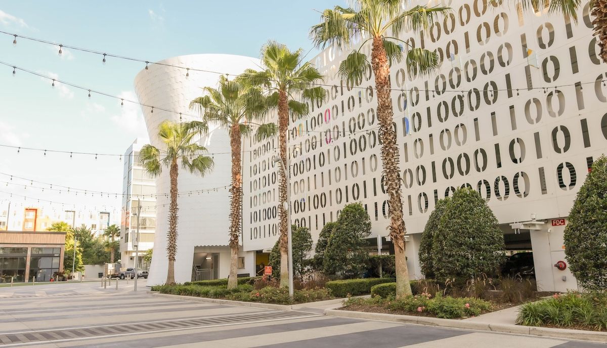 A scenic view of the Lake Nona Town center with modern buildings and palms in Florida