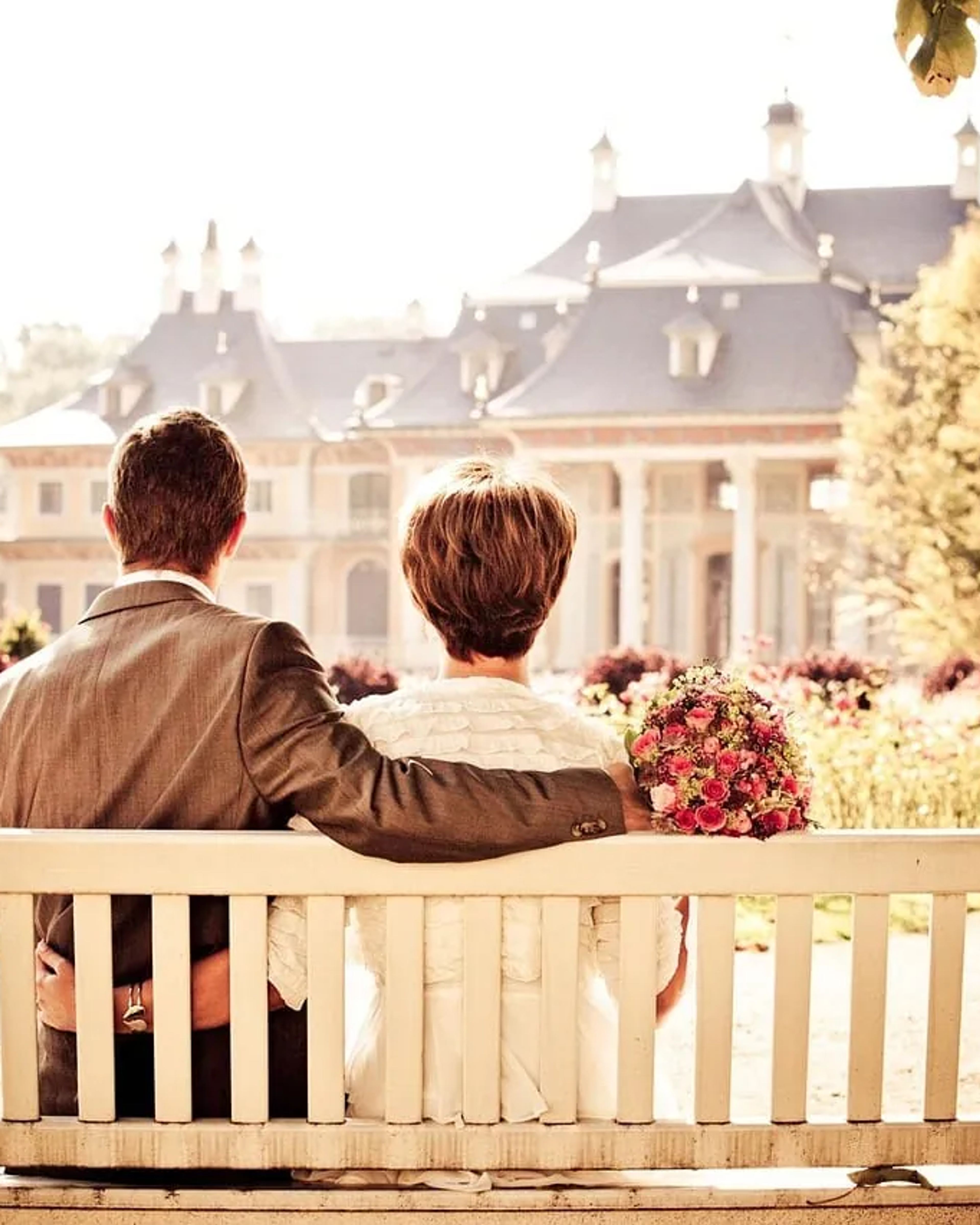 Couple on a bench in front of a castle in the evening light