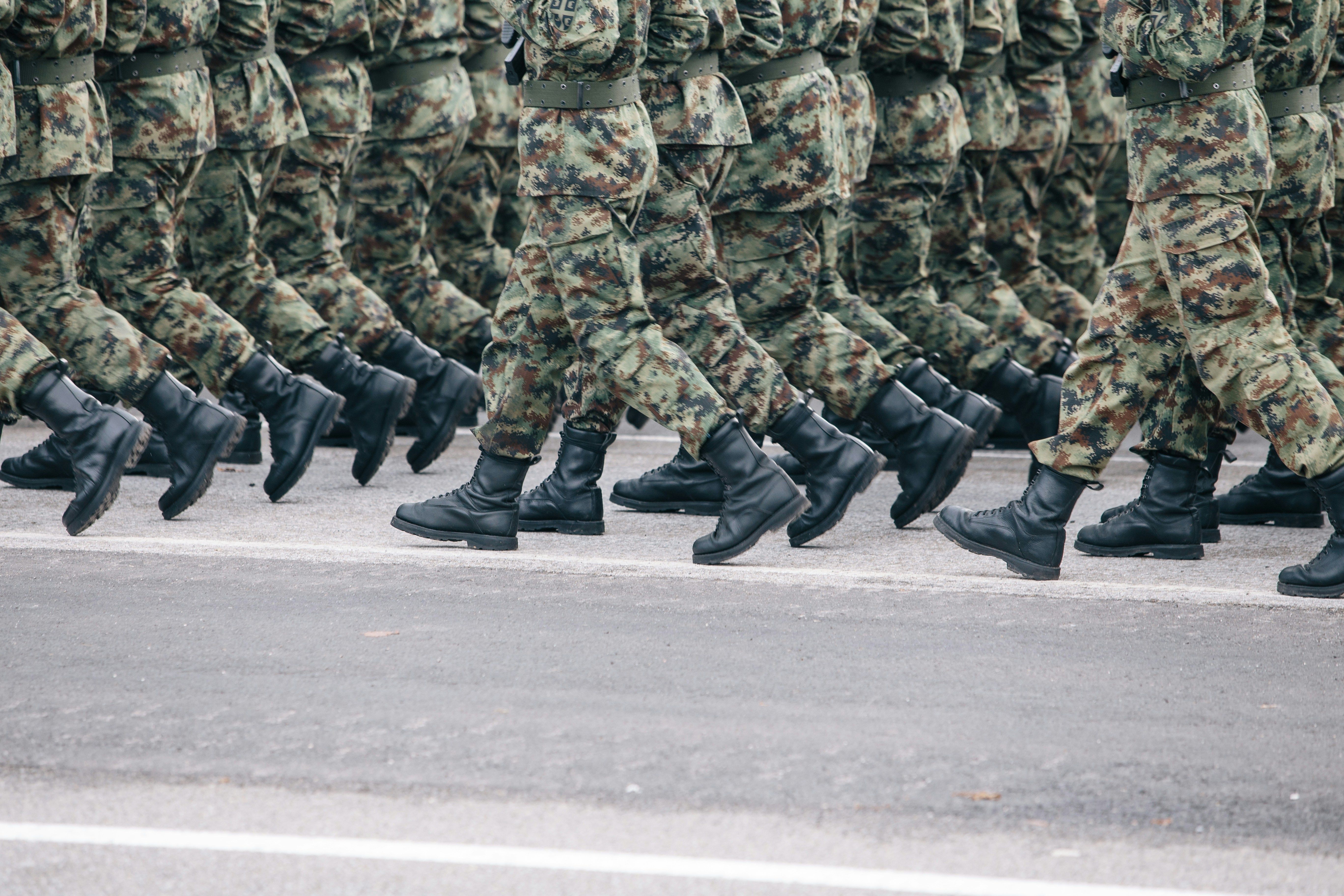 Military service members marching in uniform, representing active duty and veterans exploring personal injury claim rights in New Jersey.