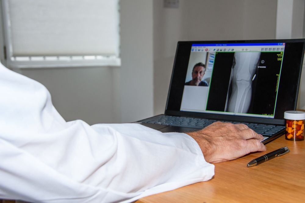 Medical professional viewing a digital X-ray, depicting the risk of misdiagnosis when a physical exam is not performed.